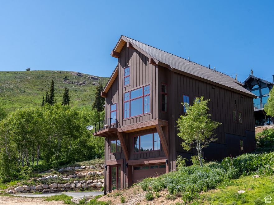 Located in Powder Mountain West, this bold contemporary retreat offers the rare thrill of true ski-in, ski-out access-your adventure starts the moment you step outside. In winter, carve fresh lines to your doorstep; in summer, hit world-class mountain biking trails that wind through wildflower meadows and alpine forests. Inside, dramatic architecture meets cozy refinement. A one-of-a-kind rotating wood-burning fireplace anchors the great room, while expansive decks frame endless views-from storm-chased peaks to golden sunsets. Every detail is deliberate: rich walnut flooring, sustainable design elements, and a seamless connection to nature at every turn. This isn't just a home-it's a year-round mountain sanctuary, built for those who chase powder in winter and singletrack in summer. Live boldly. Breathe deeply. Welcome to your mountain masterpiece. Buyer to verify all.