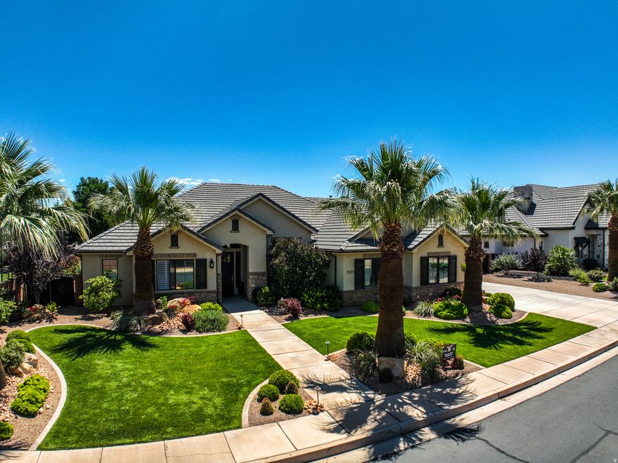 Luxury and casual living can coexist. This custom-appointed 5-bedroom, 3-bathroom home is in Crimson View school boundaries, on Dixie Power, and offers all the quality upgrades you'd expect. High-end custom finishes, coffered ceilings, plantation shutters, striking contrasting cabinetry, and elegant quartz countertops are complemented by a spacious pantry, ample storage, and generously sized closets. Curb appeal begins the moment you arrive, with a yard framed by palm trees inviting you to the entry. The great room and the open-concept kitchen and dining area flow seamlessly for gatherings, whether it's game day with friends or a formal dinner service. The backyard is private and lush, a perfect retreat. Need garage space? The 4-car garage with sealed floors provides abundant room to protect and secure all your vehicles and gear. Call to view today! Located in Bridle Gate Estates, Little Valley, Bridle Gate offers exclusive equestrian privileges within the community and convenient access to almost everything in greater St George.