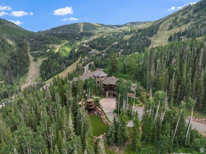 Welcome to a rare and remarkable mountain retreat, where unmatched privacy meets refined alpine living. Perched on one of the most desirable homesites in the exclusive Colony at White Pine Canyon, this five-bedroom, five full and four half-bathroom estate offers panoramic ski resort views, direct ski-in/ski-out access, and the ultimate in year-round mountain living. Spanning multiple levels and serviced by a central elevator, the home is designed with timeless mountain finishes-rich woodwork, natural stone, and vaulted ceilings that frame breathtaking alpine views. Every detail has been thoughtfully curated to balance elegance and comfort, creating a space that feels both grand and inviting. The main living areas flow effortlessly, from the formal living room with its statement fireplace and expansive windows, to a warm and intimate hearth room ideal for quiet mornings or aprs-ski relaxation. The spacious family room, complete with a wet bar, is designed for entertaining, while the dedicated media and recreation room adds a layer of fun and function. A private office provides a serene and productive workspace, and a separate workout room ensures wellness is always within reach. Outside, the living experience continues with a series of extraordinary outdoor spaces. Heated patios allow for year-round enjoyment, and the custom fire pit and oversized hot tub offer the perfect place to unwind beneath the stars. A large turf playing field welcomes family games and summer gatherings, while a whimsical children's playhouse-tucked into the trees-makes this retreat just as magical for little adventurers. With direct ski access from your doorstep, the home offers unmatched convenience for skiers of all levels. Whether you're heading out for first tracks or coming home for lunch by the fire, the mountain is quite literally at your feet. Set on 6.87 acres, surrounded by towering evergreens and untouched wilderness, the property offers total seclusion-your own private forest-while still just minutes from the world-class dining, shopping, and cultural offerings of Park City. This is more than just a home. It's a place where generations will gather, adventures will unfold, and memories will be made for years to come. A private lodge. A year-round sanctuary. A mountain legacy unlike any other.