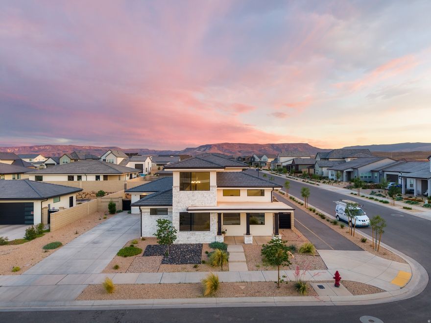 **MOTIVATED SELLER***Experience resort-style living at its finest in this stunning, smart-wired home located in the highly sought-after Desert Color community. Perfectly positioned on a desirable corner lot, this 5-bedroom, 2.5-bathroom retreat offers an open-concept design with soaring ceilings, huge windows that flood the space with natural light, and breathtaking mountain views. The chef's kitchen features custom cabinetry, beautiful accent walls, and a spacious island. The primary suite is conveniently located on the main level and boasts a grand spa-like bathroom. Designer details throughout include gorgeous draperies, stylish finishes, and thoughtfully curated spaces. The 3-car garage has room for all your adventure gear, whether it's paddleboards for the lagoon, bikes for exploring community trails, or extra toys. Just steps from your door, you'll find the spectacular Desert Color Lagoon, clubhouse, pools, spa, and pickleball courts, making this one of the best locations in the neighborhood. Living here means enjoying: Sparkling pool & sandy lagoon with cabana and paddleboard rentals, multiple pickleball courts & beach volleyball, scenic bike paths & green spaces, playgrounds, gathering areas, and an active community vibe, BIG SHOTS golf only minutes away! This home perfectly blends comfort, energy efficiency, and an unbeatable location, offering the ultimate Southern Utah lifestyle in one of St. George's most desirable communities.