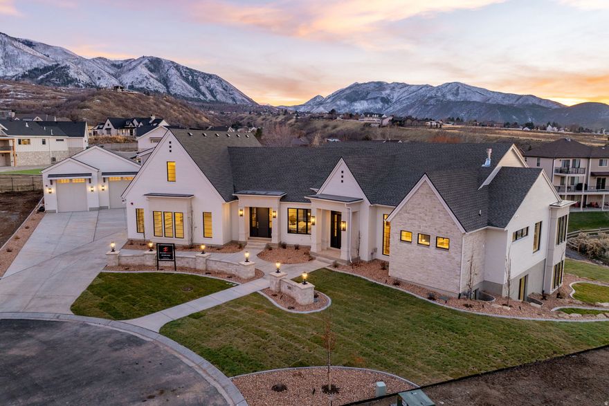 MASSIVE PRICE REDUCTION!  Luxury, space, and unbeatable privacy come together in this standout estate. Set on a hard-to-find -acre lot at the back of a quiet cul-de-sac in the four seasons subdivision, this newly built 8,000+ sq ft residence offers the kind of setting and craftsmanship rarely available in South Utah County.  From the moment you step inside, the quality is undeniable. White oak flooring, custom cabinetry, high-end quartz countertops, designer lighting, and a custom fireplace set an elevated tone throughout. The main level is open, spacious, and thoughtfully designed-a place where family and friends can gather comfortably. The gourmet kitchen is complemented by an oversized butler's pantry, while the large laundry room and private office entrance add true convenience.  The primary suite is a luxurious retreat featuring a pass-through fireplace, Rainhead showerheads, and a fully custom master closet crafted with exceptional detail.  The walkout basement continues the home's impressive design, offering exceptional spaces for gathering. Complete with a 20 foot bartop, theater room, golf simulator room, gym, and a second kitchen and expansive lounge areas-perfect for holidays, parties, and everyday family time.  A separate ADU apartment above-  with its own full kitchen adds valuable flexibility for guests, family, or rental income.  Outside, the home is fully landscaped with concrete walkways, a stone wall and features a detached 45-foot double-door RV garage-perfect for RVs, trailers, toys, or additional storage.