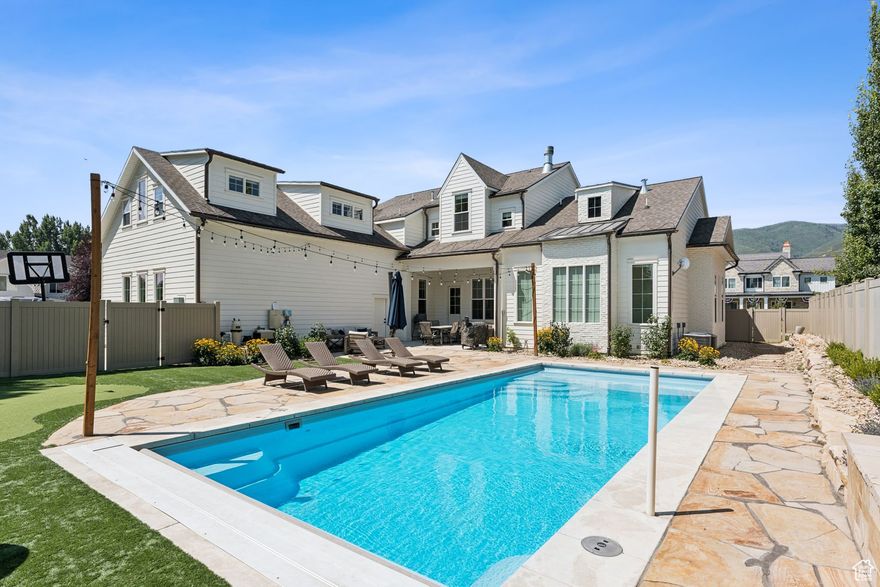 Built in 2022 on a cul-de-sac in charming Midway, this stunning custom home blends timeless elegance, modern comfort, and resort-style living. From its wrap-around porch to its professionally curated interior, every detail has been crafted to impress.  Inside, a light-filled open floor plan connects inviting gathering spaces with private retreats. The chic chef's kitchen is a dream boasting an Italian made ILVE gas range, double islands, a Venetian plaster hood, and a spacious butler's pantry with an extra oven, dishwasher, sink and second refrigerator. The main-floor primary suite features dual closets, a soaker tub, spa like shower and its own laundry.  Next to the main-level suite is a home office with custom built-ins that can double as a sixth bedroom or nursery.  Four additional bedrooms (two are ensuite) and a bonus room upstairs offer comfort and privacy for all.   The fully fenced backyard is your private resort-complete with a heated fiberglass pool with automatic cover, a putting green and playhouse. Additional highlights include 3 car garage, craft room, mud room, laundry on each floor and extra RV/boat parking.  Just a short stroll to historic Main Street's shops, dining, and farmer's markets-and minutes from hiking, biking, golf, skiing, and Utah's pristine lakes and rivers-this home blends mountain charm, thoughtful design, and everyday luxury in perfect harmony.