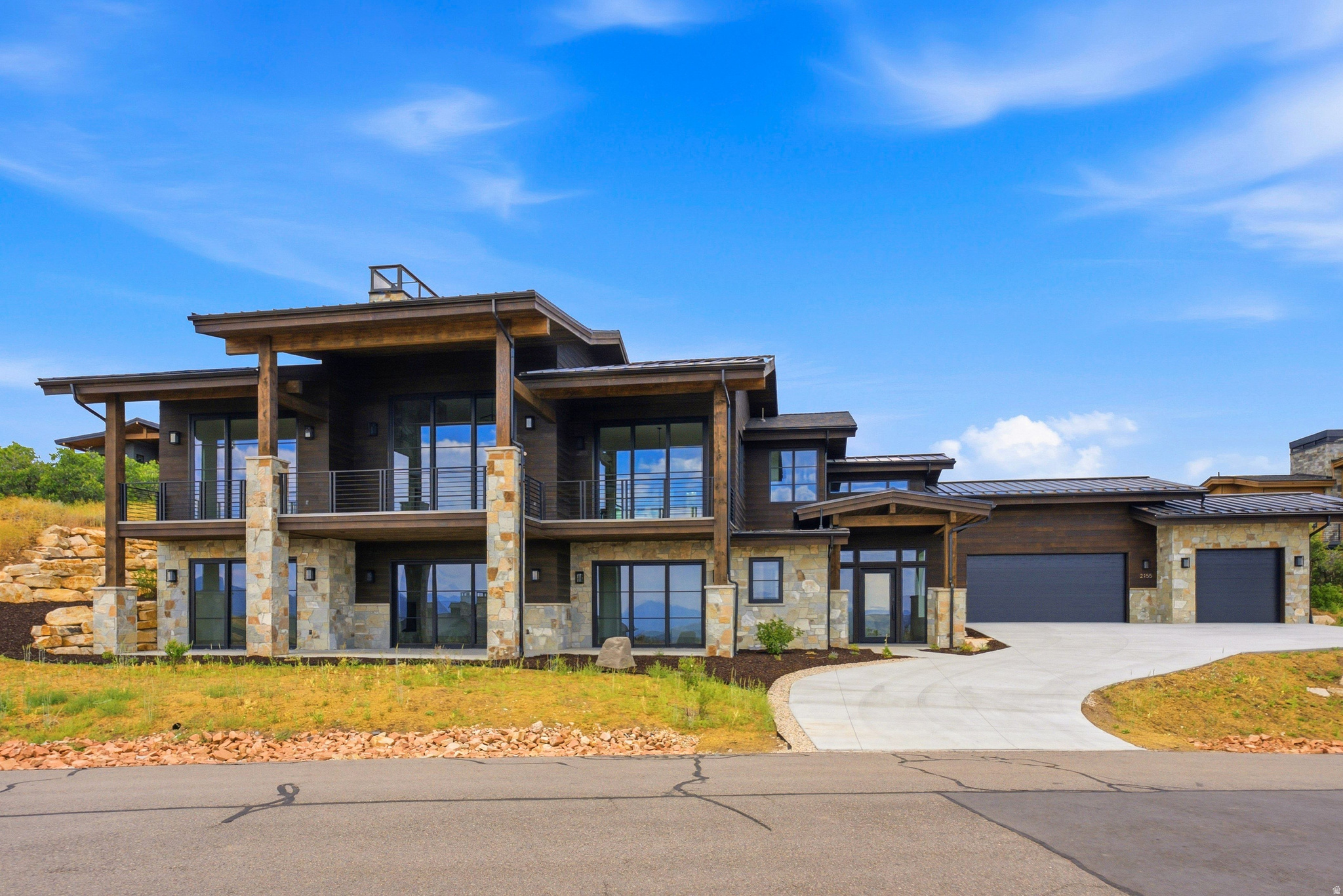 Contemporary multi-level residence featuring a stone and wood-paneled exterior