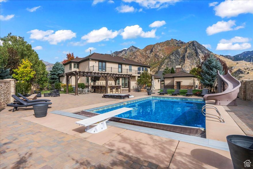 This stunning estate in Alpine, Utah, is a masterpiece of luxury and comfort. The home boasts a detached 6-car garage, a luxury resort-style backyard, radiant floor heating, a movie theater, a mother-in-law apartment, and some of the most beautiful, unobstructed views of the mountains and Utah Lake that you'll find. A serene water feature enhances the ambiance upon entry to the home. The interior is beautifully finished with hardwood floors that are heated and vaulted ceilings, creating an airy and open feel.  Custom cabinets and shelving adorn the office, a kids' study, and an extremely large custom closet/room off the master. Three separate furnaces, one for each floor. It includes a separate mother-in-law apartment with a kitchen, laundry, and private entrance for added convenience and privacy.  Step outside onto the large second-floor balcony, where breathtaking, unobstructed views of the majestic mountains and Utah Lake will greet you. The property is extremely private with no visual obstructions. Car enthusiasts will appreciate the detached RV/boat garage and an incredible 10 total garage parking spaces. The detached garage has heating and cooling, air compressors, electricity, is 35 feet deep, and has 10-foot doors. For outdoor living, the home is second to none. It features a saltwater pool, a built-in hot tub, a natural gas fire pit, and an outdoor kitchen that includes a sink, BBQ, fridge, TV, surround sound, and seating for 13 people. Professional exterior lighting creates a beautiful evening atmosphere, and an indoor and outdoor surround sound system ensures your music can follow you wherever you go. Additional highlights include an advanced irrigation system, two separate staircases leading to the second floor, and two balconies on the upper level that offer some of the most spectacular views from the front and back imaginable. You'll be the master of entertainment, inside and out, at this luxury estate!