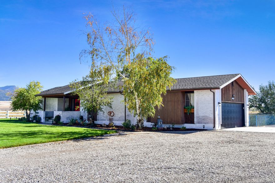 A mid-century modern dream, this classic ranch style home is a must see. Nestled in beautiful Downey, Idaho, this home sits on over 13 acres with 360 degrees of amazing views. Featuring a white washed brick exterior, when walking to the front door you will be welcomed by double entry doors and a covered porch. Entering through the front door, you'll find a spacious, open floor plan with large picture windows. The home also features a double fire place between the kitchen and dining room providing ambiance for entertaining or a quiet evening at home. The updated kitchen is complete with quartz countertops, tiled backsplash, and stainless steel appliances. Just down the hall from the kitchen sits the pantry, laundry room, and bathroom. Spacious master bedroom with walk-in closet and master bathroom. Venture to the basement into the large family room where you can enjoy comfy evenings with the wood burning stove. Three additional bedrooms and a bathroom can be found downstairs. The basement also features a wine cellar, and cold storage. The exterior of this home is just as amazing as the inside with the open deck, fully fenced yard, and beautiful landscaping. Love gardening? You'll enjoy the eight raised garden beds with commercial grade weed barrier for low maintenance. Outside you'll also find a 30'x48' shop. Don't miss the opportunity to own this amazing home.