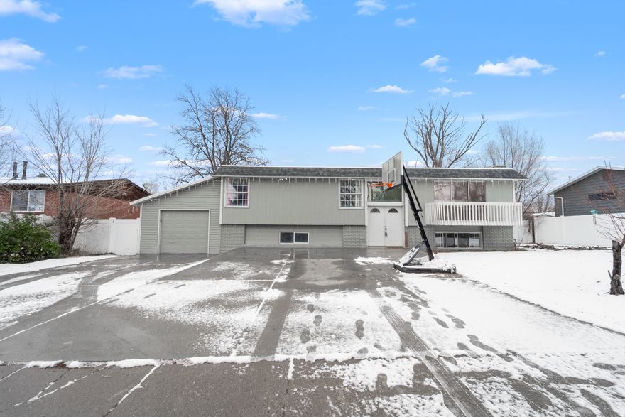 This bright and roomy home is nestled in a desirable East Sandy neighborhood, offering easy access to shopping, dining, parks, top-rated schools, flat iron park, falcon park, and just minutes from world-class ski resorts. Step inside to an inviting entry highlighted by sleek gray-toned flooring and a contemporary chandelier that sets the tone throughout. The open-concept kitchen and great room create a warm, welcoming space ideal for everyday living and entertaining. The beautifully updated kitchen features modern gray cabinetry, a stylish tile backsplash, a center island, stainless steel appliances, and elegant quartz countertops. Adjacent to the kitchen, the great room offers a cozy fireplace for relaxing evenings, along with sliding glass doors that lead to a balcony showcasing breathtaking mountain views. The main level includes a generous primary bedroom with an ensuite bathroom featuring a tiled shower. Two additional spacious bedrooms and a full bathroom complete this floor. Downstairs, the fully finished basement offers a large family or theater room, two oversized bedrooms, a full bathroom, and a convenient laundry area. From the kitchen, step out onto the covered deck to take in the mountain scenery, or head down to the expansive, fully fenced backyard-perfect for gatherings, play, or outdoor relaxation. Parking is plentiful with a one-car garage and an oversized driveway for additional vehicles. This move-in-ready home is packed with recent upgrades completed in 2021/2022, including a new furnace, air conditioner, water heater, electrical updates, main water line, sewer line and a brand-new roof. This is one you don't want to miss out on.  Square footage figures are provided as a courtesy estimate only and were obtained from county record. Buyer is advised to obtain an independent measurement.