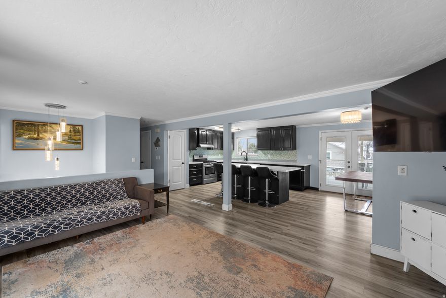 This bright and roomy home is nestled in a desirable East Sandy neighborhood, offering easy access to shopping, dining, parks, top-rated schools, flat iron park, falcon park, and just minutes from world-class ski resorts. Step inside to an inviting entry highlighted by sleek gray-toned flooring and a contemporary chandelier that sets the tone throughout. The open-concept kitchen and great room create a warm, welcoming space ideal for everyday living and entertaining. The beautifully updated kitchen features modern gray cabinetry, a stylish tile backsplash, a center island, stainless steel appliances, and elegant quartz countertops. Adjacent to the kitchen, the great room offers a cozy fireplace for relaxing evenings, along with sliding glass doors that lead to a balcony showcasing breathtaking mountain views. The main level includes a generous primary bedroom with an ensuite bathroom featuring a tiled shower. Two additional spacious bedrooms and a full bathroom complete this floor. Downstairs, the fully finished basement offers a large family or theater room, two oversized bedrooms, a full bathroom, and a convenient laundry area. From the kitchen, step out onto the covered deck to take in the mountain scenery, or head down to the expansive, fully fenced backyard-perfect for gatherings, play, or outdoor relaxation. Parking is plentiful with a one-car garage and an oversized driveway for additional vehicles. This move-in-ready home is packed with recent upgrades completed in 2021/2022, including a new furnace, air conditioner, water heater, electrical updates, main water line, sewer line and a brand-new roof. This is one you don't want to miss out on.  Square footage figures are provided as a courtesy estimate only and were obtained from county record. Buyer is advised to obtain an independent measurement.