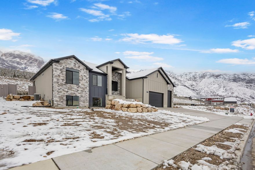 Enjoy stunning views and modern luxury in this beautifully designed new rambler, thoughtfully finished on both levels with flexible ADU potential. From the moment you step inside, you'll appreciate the open layout, soaring 9-foot ceilings on both the main floor and basement, and high-end finishes throughout. The gourmet kitchen is as functional as it is stylish, featuring a striking 66" refrigerator/freezer combo, gas cooktop, double ovens, decorative hood vented outside, and a spacious walk-in pantry-perfect for entertaining or everyday living. Gather in the inviting great room around the cozy gas log fireplace, or retreat to the luxurious primary suite complete with a freestanding soaking tub, oversized shower, double sinks, and a generous walk-in closet. The fully finished basement offers incredible versatility with a second custom kitchen, 3 additional bedrooms, a full bathroom, and a second laundry room-ideal for guests or multi-generational living. Outside, the spacious 4-car garage includes EV charging, and the RV pad is already poured and ready for your toys and adventures. This home combines comfort, style, and flexibility with breathtaking views you'll enjoy every day.