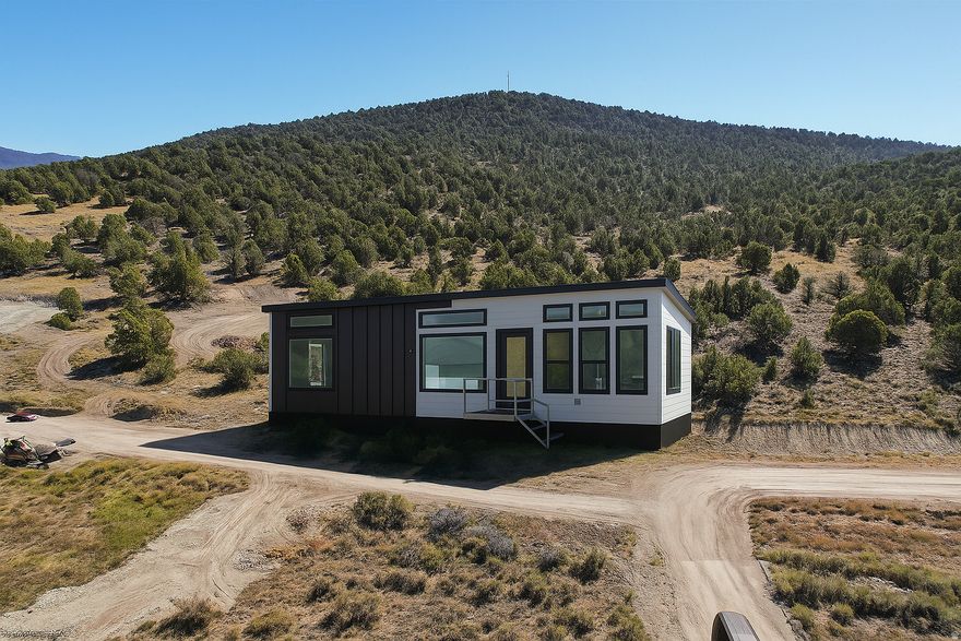 Buyer will receive a $20,000 Seller Credit to help cover connection fees and jump-start your dream project! This property is a one-of-a-kind opportunity to secure both a fully prepped building lot AND a brand-new luxury tiny home (built off-site and delivered by Summit Luxury Dwellings). Live in the tiny home while you build your future residence, generate income, or simply enjoy an elevated mountain retreat from day one. Highlights of this lot are truly endless. The lot is fully prepped and ready for construction, complete with an active operating permit. Your dream home is closer than ever. Tucked in a quiet, scenic mountain community, this parcel offers the perfect balance of seclusion, recreation, and accessibility. With year-round access and direct trail connections for ATV-ing, snowmobiling, hiking, biking, and horseback riding. Just 30 minutes from Spanish Fork Canyon and easily accessed from Highway 89. The luxury tiny home included features: High-end modern finishes; Efficient, customizable layouts; Multiple floor plans to choose from; Delivered and installed on your lot fast. This would be ideal for: Living in while you build your home; used as Guest quarters; used as an ADU; Nightly rental income; and Long-term investment flexibility. Community amenities and future perks of this development include a 2.5-acre swimming lake for paddle boarding & kayaking. There are also plans for an exclusive beach club for owners to relax and recharge! The HOA is extremely flexible, also charging just $500/year. They cover road maintenance and future amenities, while supporting creative building plans and individual design preferences. This is not your typical restrictive HOA; it's designed to empower your vision. Claim your slice of mountain heaven with a move-in-ready luxury tiny home AND a build-ready lot. Schedule your private tour today! Buyer is responsible for utilities, hookups, and final site prep.