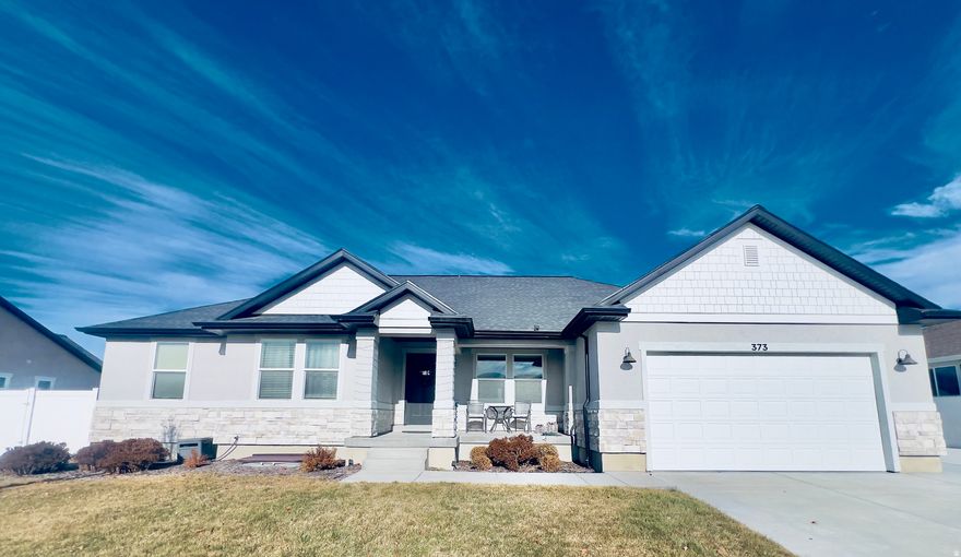 Nestled in a desirable Eagle Mountain neighborhood, this beautifully maintained 2021 rambler offers comfort, functionality, and modern design throughout. The home features a spacious walkout basement that has never been lived in, providing a rare opportunity for multi-generational living, rental potential, or extended guest space. The basement includes four bedrooms with closets, an additional oversized flex room, a full bathroom, its own washer and dryer hookups, granite countertops, brand-new gray click-lock flooring, fresh paint with 5-inch baseboards, and a fully finished kitchen with unused Whirlpool appliances, subway tile backsplash, and soft-close gray cabinetry with chrome hardware. A large kitchen and dining area, plus extra storage under the stairs, make the space both practical and inviting. The home is equipped with all newer utilities, including a tankless water heater and water softener, offering efficiency and peace of mind. Outside, enjoy a bright east-facing walkout basement, ample parking, and a dedicated RV pad-perfect for toys, trailers, or extra vehicles. With modern finishes throughout, generous living space, and thoughtful upgrades, this home offers flexibility, value, and long-term comfort in one complete package.