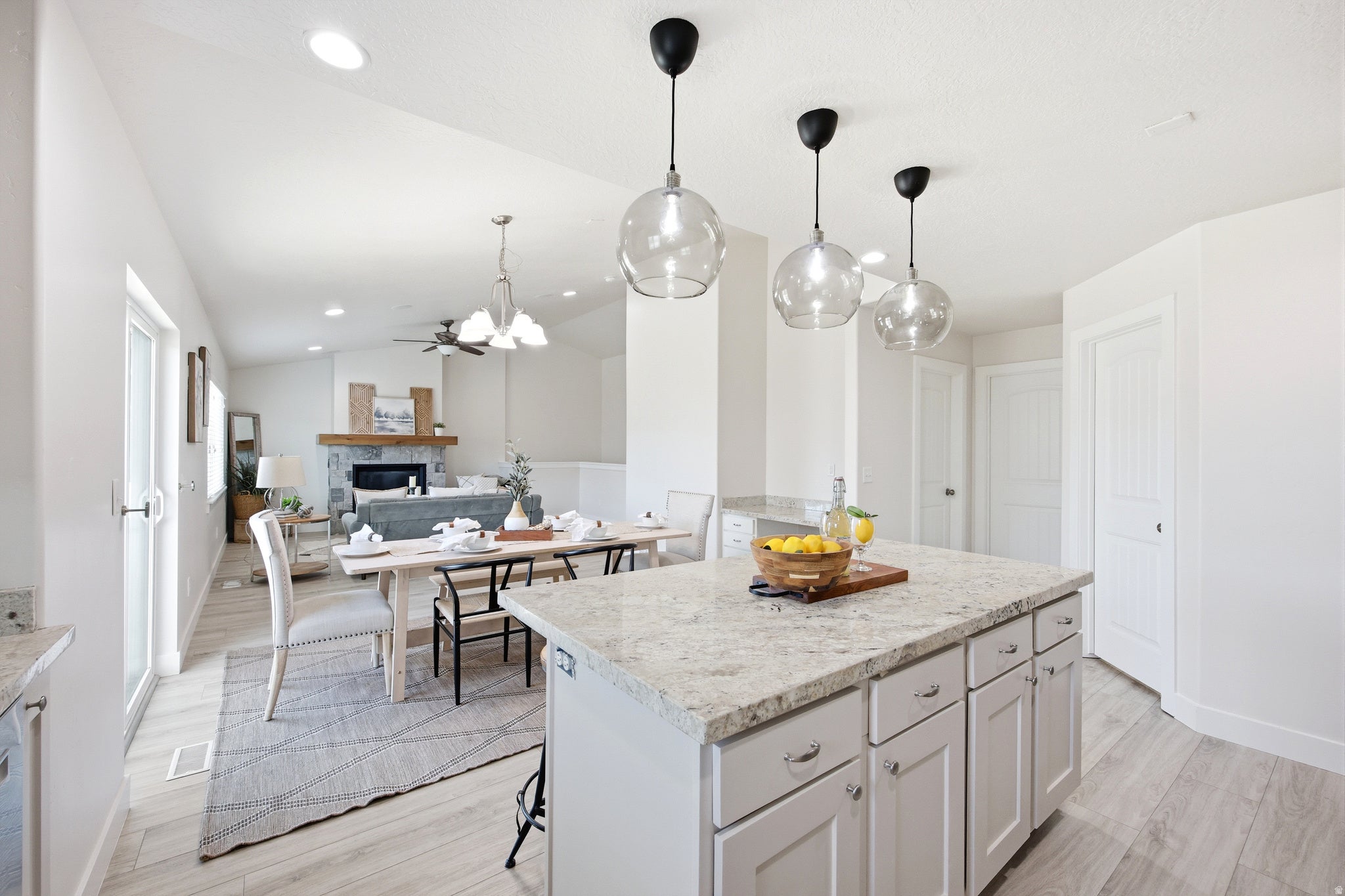 Kitchen island with light-toned countertop and pendant lighting