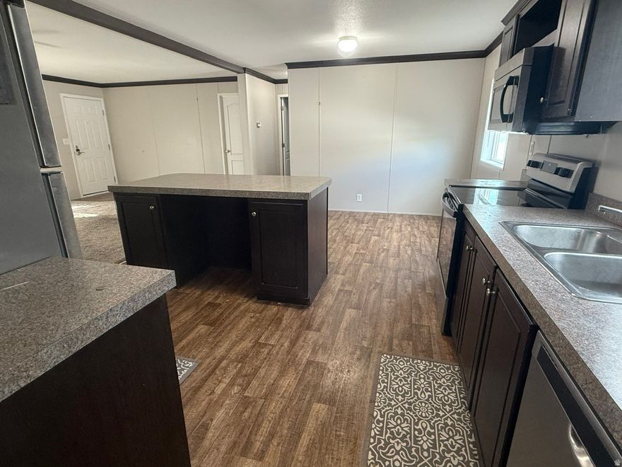 Make an offer! Seller motivated! Welcome home to easy, single-level living in this bright and well-kept 3 bedroom, 2 bathroom manufactured home. An open-concept living room flows into a spacious kitchen with abundant cabinet space, a breakfast bar, and a dining nook-great for everyday meals or hosting friends. The split-bedroom layout gives the master bedroom added privacy, featuring an ensuite bath and walk-in closet. Two additional bedrooms and a full bath offer flexible space for family, guests, a home office, or hobbies. A dedicated laundry room adds everyday convenience. Outside, enjoy a covered porch, low-maintenance yard, and 3-car covered parking.