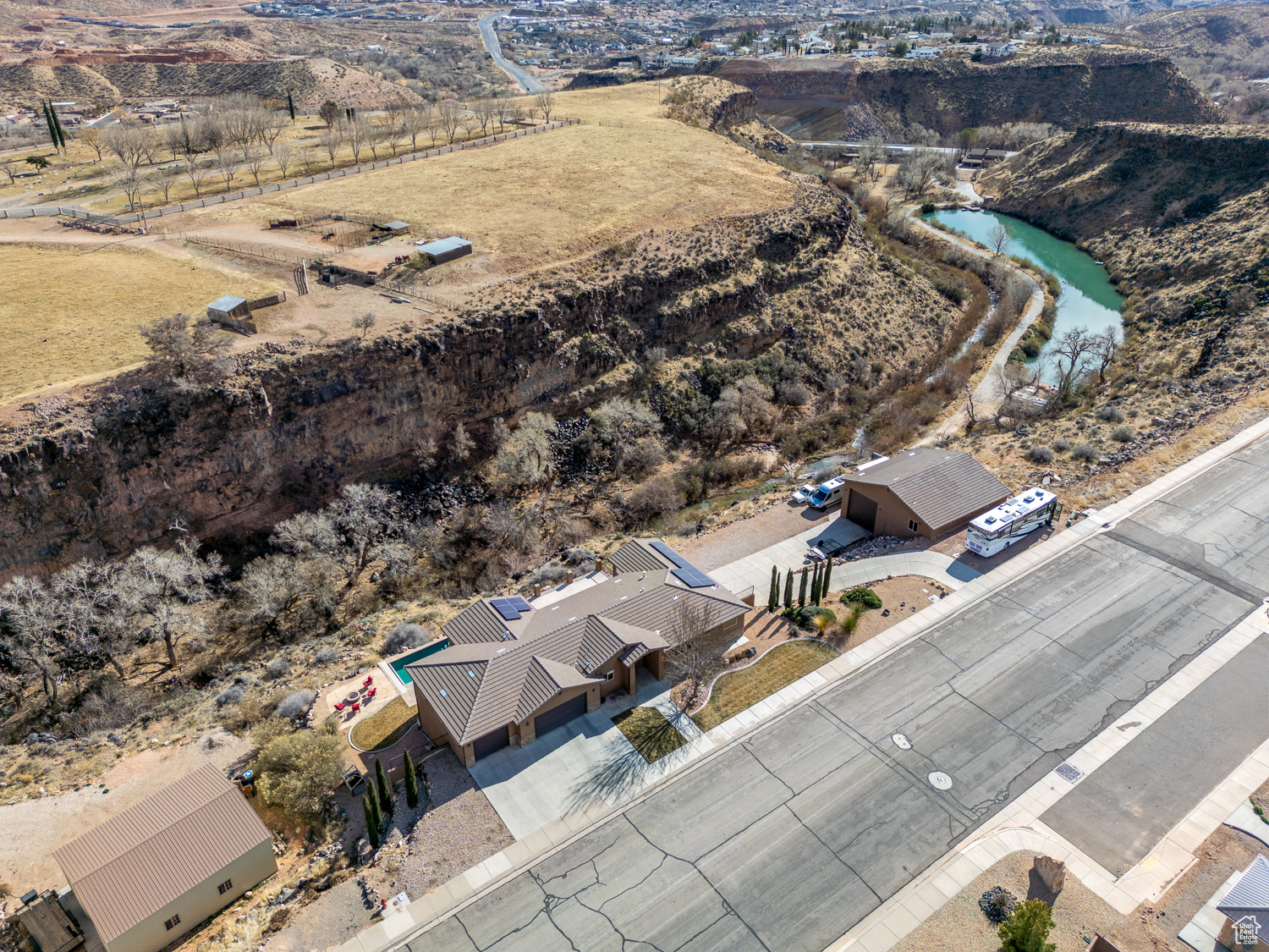 This home has it ALL; 4386 sq ft, pool, workshop, and more! This estate is perfectly perched on the cliffs above Ash Creek, offering unmatched panoramic views of the stunning mesas. Situated on a spacious 0.82-acre lot, this property is designed for luxury and functionality. Inside, you'll find 5 beds and 4 full baths, with an open-concept floor plan that seamlessly blends function, comfort and style. The walk-out basement provides additional living space and easy access to the incredible backyard retreat. Step outside to your private oasis, featuring a saltwater pool, ample RV parking, and plenty of room to entertain or relax while taking in the breathtaking scenery. The 3-car attached garage is complemented by a detached 1,600 sq. ft. shop, perfect for hobbies, storage, or add'l parking. Energy efficiency meets modern convenience with fully owned solar panels, helping to reduce utility costs. Too many upgrades to list! Don't miss the chance to own this rare gem in Toquerville where luxury, space, and stunning views come together in perfect harmony!