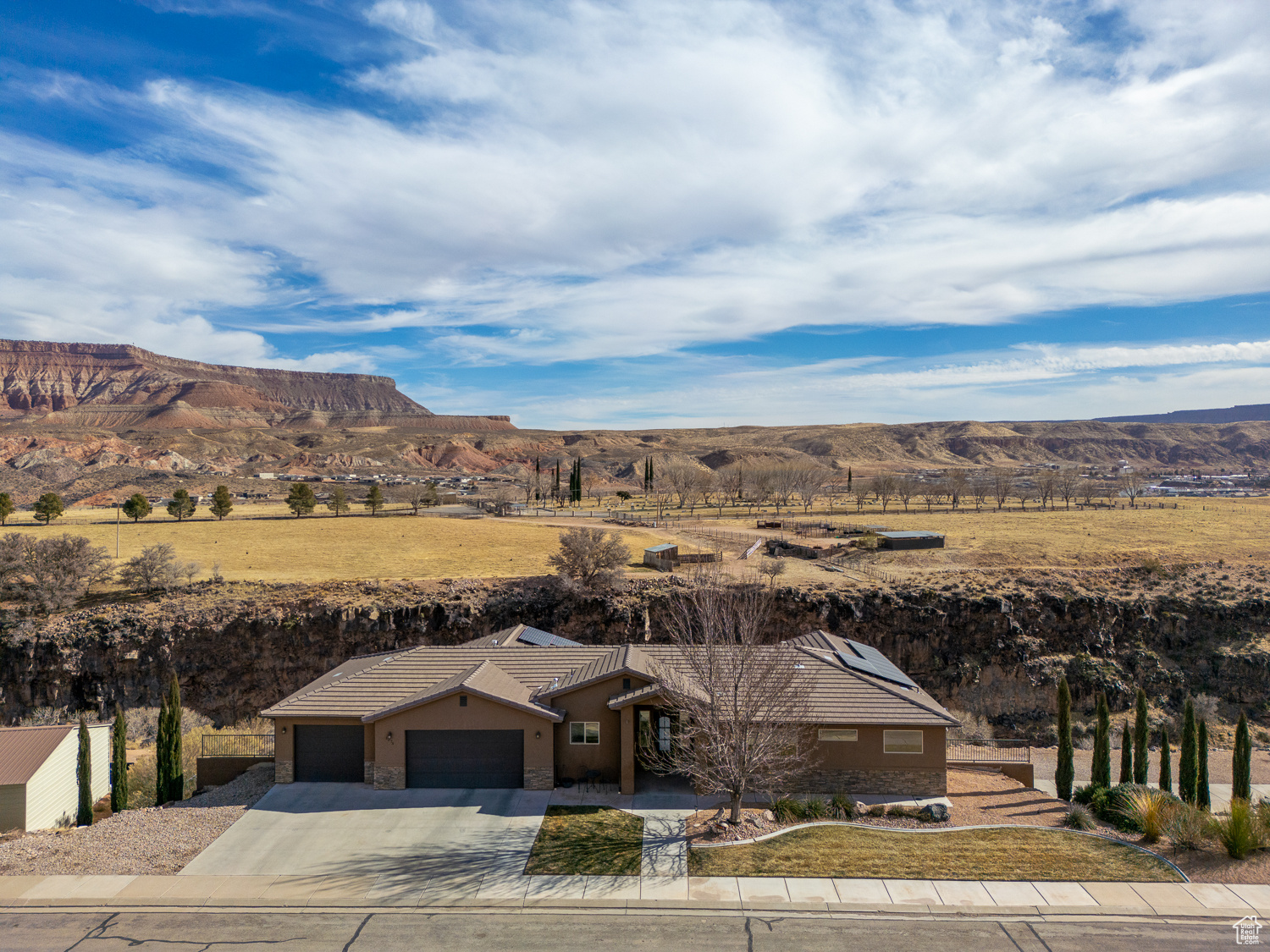 Welcome to your dream home! This 4,386 sqft estate is perfectly perched on the cliffs above Ash Creek, offering unmatched panoramic views of the stunning mesas. Situated on a spacious 0.82-acre lot, this property is designed for luxury and functionality. Inside, you'll find 5 beds and 4 full baths, with an open-concept floor plan that seamlessly blends function, comfort and style. The walk-out basement provides additional living space and easy access to the incredible backyard retreat. Step outside to your private oasis, featuring a saltwater pool, ample RV parking, and plenty of room to entertain or relax while taking in the breathtaking scenery. The 3-car attached garage is complemented by a detached 1,600 sq. ft. shop, perfect for hobbies, storage, or add'l parking. Energy efficiency meets modern convenience with fully owned solar panels, helping to reduce utility costs. Too many upgrades to list! Don't miss the chance to own this rare gem in Toquerville where luxury, space, and stunning views come together in perfect harmony!