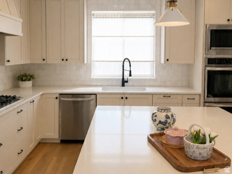 Kitchen featuring wood-finish flooring, recessed lighting, and a kitchen island with a light-toned countertop
