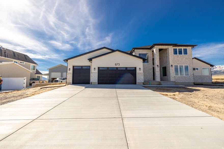 Beautiful 4-bed, 2.5-bath home on a spacious .51-acre lot in Granstville, UT. Bright, open floor plan with plenty of natural light, generous bedrooms, and modern finishes throughout. Enjoy wide-open, panoramic views and outdoor space perfect for gardening, entertaining, or relaxing. Third car garage door is 9'x9'  Extra garage/shop has a 14'x14' garage door opening and dimensions are 21'x36'x16' tall perfect to store your RV. The extra garage is 70% complete & is  perfect for someone who likes having a project to complete. This home offers nice rural living with country feel without having to go too far-your peaceful retreat awaits.