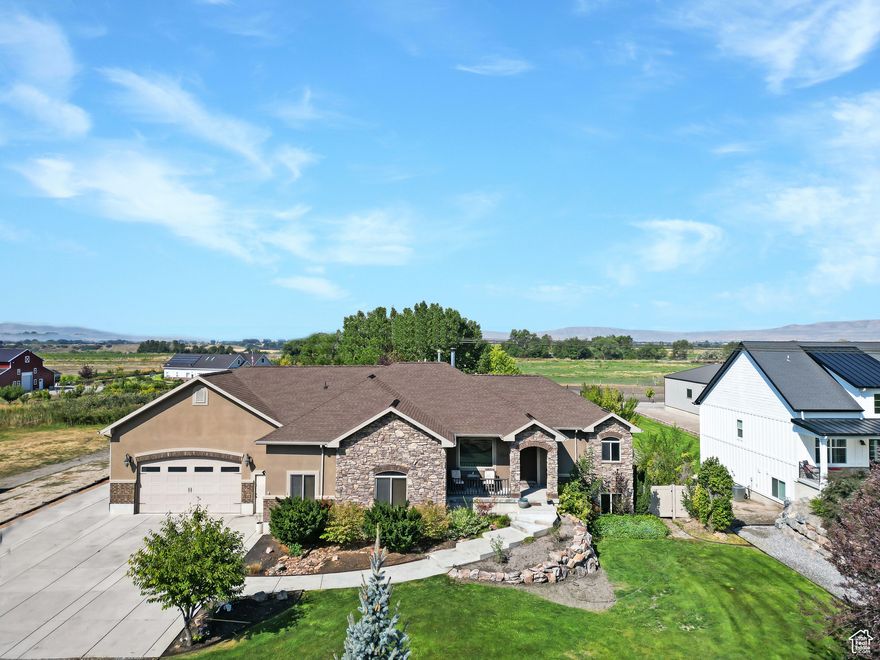 Welcome to this stunning country home in Deweyville, capturing sunset views over the Coldwater Mountain Range. The open-concept layout boasts a sunlit kitchen, great room, and a master suite with a walkout sunroom featuring a see-through gas fireplace, jetted tub, and double walk-in shower. The lower level offers additional living with a kitchenette and beauty salon, along with laundry on both levels. A mudroom with custom cabinets and lockers adds convenience, while landscaped grounds showcase a waterfall, mature trees, and a spacious garage with RV parking plus an outbuilding for ample storage. Available to pre-qualified buyers only. Square footage figures are from county records; buyer to verify.