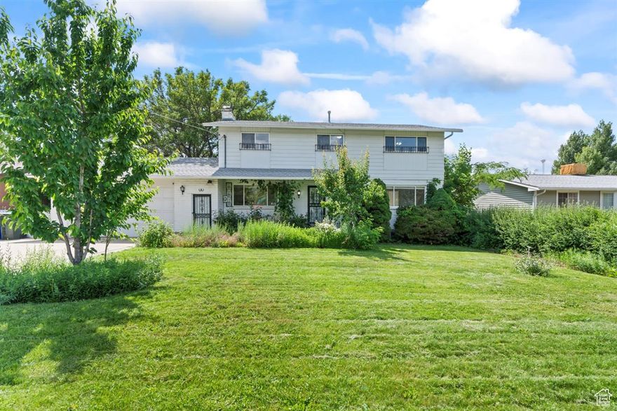 Tooele city has a secret garden! This charming 5 bedroom, 2 full baths, 2 half baths home is nestled on .48 acre horse property with 2 water shares. The 2-story home offers plenty of room for multi-generational living, and even a business, with space for an RV or customer parking. On the main level, there is a dedicated home office with a wood burning stove, kitchen, formal dining room, laundry, and half bath. The full basement has a half bath, two large storage rooms, and a separate entrance. The second story has four bedrooms with a full bath, and a master bedroom with its own private full bath, his and hers closets, and an additional storage closet. The oversized two-car garage has a built-in work space, attic storage, and its own gas heating system. The yard, front and back, has been pesticide and herbicide free for over ten years. It harbors an orchard, vineyard, wild forage, wild medicinal plants, and rare birds, butterflies, and other animals. Orchard trees: multiple cherry, apple, pear, plum, apricot, peach, English Walnut, and Filbert Chestnut. Berries: Globe and green seedless grapes, golden currant, and red raspberry. A stocked root garden, amaranth, sweet mint, roses, orchids, poppies, and many other flowers. It has a sheep pasture with carefully cultivated triticale, tall fescue, meadow brome, alfalfa, sweet clover, and orchard grass. Chickens, including roosters, are welcome. There is also a dedicated dog run. This property offers a peace-filled biodiverse food forest and ecosystem in your own backyard. Located just five minutes from shopping, schools, hiking/riding/walking trails, year-round indoor swimming, theaters, and more.  While filled with potential, this home does need updating and some tlc; it is being sold "as is".