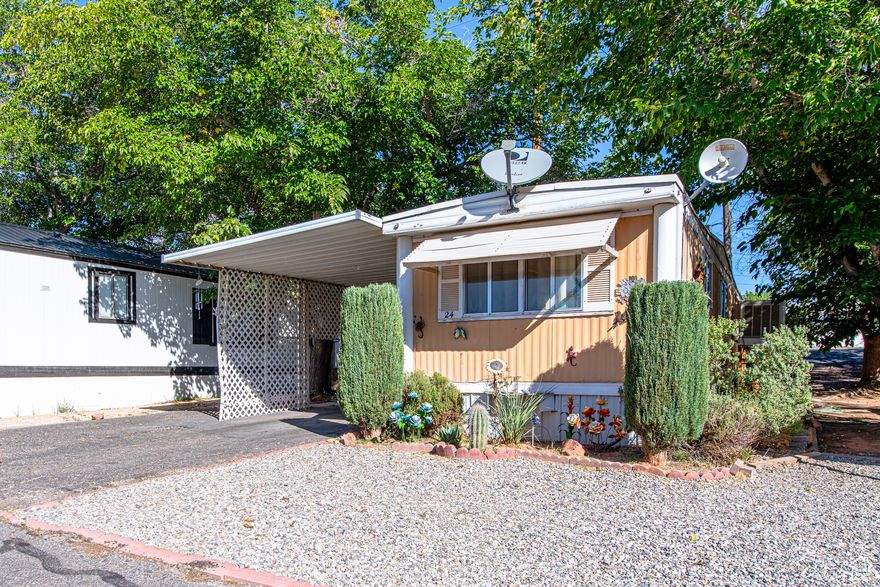 Cozy, eclectic, and vintage best describe this charming 2-bedroom, 1-bath mobile home nestled in the quiet Pleasant View MHP. A striking Saguaro cactus and a colorful mural showcasing Southern Utah's desert landscape - complete with a playful Gila Monster - give this home its unique personality.  Recent updates include a wheelchair ramp, newer skirting, new subflooring, a 1-year-old water heater, a 5-year-old roof, and 6-year-old carpet. An 8' x 14' shed with power provides plenty of extra storage, while the 180 sq. ft. covered patio offers a cool, shaded retreat year-round.  The side yard features a fenced area perfect for pets, and you're just a short stroll away from Washington's popular Dog Park.