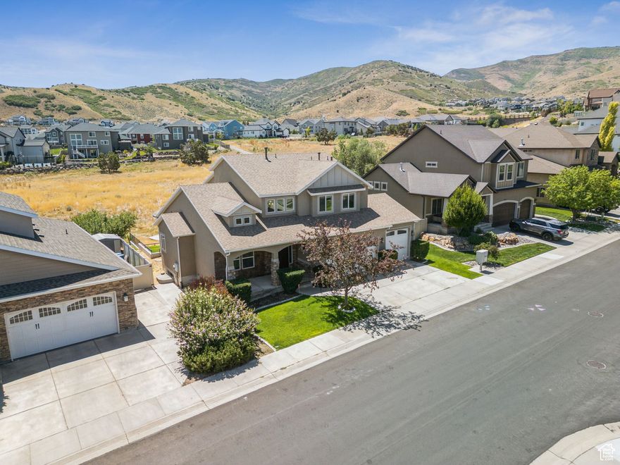 Welcome to Juniper Point! This beautifully maintained home offers breathtaking views of the Wasatch Mountains and is located just steps from the community clubhouse, pool, trails, and sports courts. The main level features soaring ceilings, hardwood floors, and a versatile front room perfect for an office or sitting area. The open-concept kitchen, dining, and family room are ideal for entertaining, complete with a cozy fireplace and access to a covered deck with no rear neighbors. The spacious main-floor primary suite includes dual sinks, a walk-in shower, an oversized soaking tub, and a walk-in closet. Upstairs, you'll find three large bedrooms and a full bathroom. The daylight walkout basement is fully finished with 9' ceilings, a second full kitchen, three additional bedrooms, and direct access to a private, landscaped backyard-perfect for multi-generational living or rental income. Additional features include a brand-new roof with a warranty, a three-car garage-third car garage has a 10' tall door, proximity to Providence Hall Charter School, and easy access to Mountain View Village, shopping, dining, and SLC commuter routes.