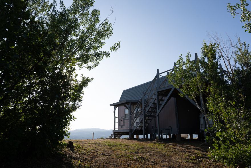 Some places just speak to the soul. You'll know it the moment you arrive. Tucked into the peaceful landscape of Hardware Park Mountain Estates, this fully furnished cabin sits on 20.51 acres of your very own mountain side. With nothing but sky overhead and Scare Canyon stretched out below, it's the kind of place that quiets your thoughts and reminds you how beautiful life can be. The land itself is a rare mix: meadow, forest, and open hillside, all inside a private gated community where views stay untouched and the only sounds you'll hear are wind in the trees and the occasional elk passing through. Two adjoining parcels are included (16-095-0023 & 16-095-0058) and will be sold together, giving you both space and privacy that's getting harder to find. This is a seasonal retreat, meticulously built with the finest materials and craftsmanship of its time, and thoughtfully maintained ever since. The interior is filled with handcrafted wood log furniture, cozy charm, and simple comforts that make it feel like home the moment you step inside. If you've been dreaming of a place to unplug, reconnect, and take a deep breath, this might be it. Come see what life feels like at the top of the world.