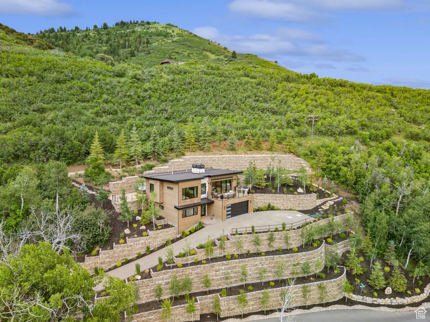 Welcome to 1400 Weber Wild, a private retreat that blends luxury, nature, and serenity into a one-of-a-kind living experience. This stunning 4-bedroom, 3-bathroom residence spans 2,300 square feet and is thoughtfully nestled into the mountainside, offering unmatched views across the picturesque Oakley Valley.  From the moment you arrive, you're greeted by the soothing sound of the Weber River, which can be heard gently flowing from the expansive front porch. The setting is pure magic-towering pines, abundant wildlife, and unobstructed vistas as far as the eye can see.  Designed for both comfort and connection, this home features generous indoor-outdoor living spaces ideal for relaxing or entertaining. Fully matured landscaping requires minimal maintenance.   Inside, you'll find the signature Harwood Homes touch-high-end appliances, custom cabinetry, and premium finishes throughout.  The massive front deck is anchored by a grand stone fireplace and a built-in barbecue zone, perfect for gatherings under the stars. Around back, a secluded patio and hot tub create the perfect escape, framed by alpine views and frequent deer sightings.  Inside, you'll find a warm, open layout with vaulted ceilings, wood accents, and large picture windows that bring the outdoors in. Every room is positioned to maximize natural light and showcase the surrounding landscape. Whether you're watching chipmunks scurry through the trees or sipping coffee as the morning sun lights up the valley, life here moves at a slower, more meaningful pace.  1400 Weber Wild isn't just a home-it's a sanctuary.
