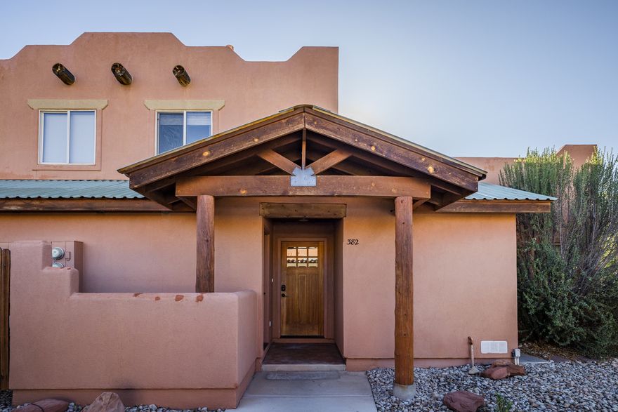 BRIGHT TOWNHOME! This well-appointed, move-in ready Mill Creek Pueblo townhome offers a functional layout with thoughtful storage and comfortable living spaces throughout. On the main level, you'll find a dedicated laundry room with shelving, a convenient half bathroom, and additional storage tucked neatly under the stairs. The kitchen is designed for both everyday living and entertaining, complete with stainless steel appliances, generous counter space, and ample cabinetry. A breakfast bar provides seating for taller stools and opens to a combined dining and living area that's spacious enough to create defined zones without sacrificing flow. The living room is highlighted by striking wood beam accents that add warmth and character, while sliding glass doors lead directly to the back patio. Step outside to enjoy a quiet, grassy area and a sense of privacy set apart from neighboring units. Upstairs, you'll find two generously sized bedrooms. One bedroom features direct access to the full bathroom, while the second is just down the hallway. Fresh white paint throughout enhances the home's light and airy feel. Located in one of Moab's most convenient areas, this property is just moments from Milt's Stop & Eat, Dave's Corner Market, and Rize Studio, with easy access to the Mill Creek Parkway. Community amenities include a pool, maintained green spaces, and direct parkway access, offering a low-maintenance lifestyle in a park-like setting.