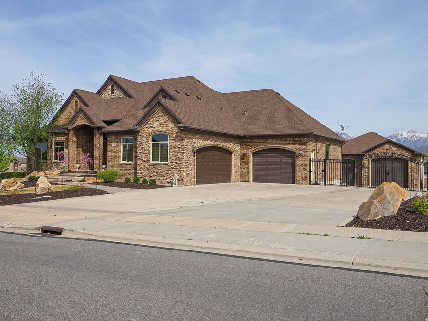 Exceptional Bluffdale luxury estate offering a rare combination of lifestyle and function. Situated with sweeping Wasatch Mountain views, this high-quality custom home features a swimming pool, horse-ready pasture, and an impressive 40' x 50' heated detached garage with oversized 14' doors, 16' ceilings, and a dedicated pool bath. Inside, enjoy a gourmet kitchen with premium appliances, a second full kitchen in the lower level for entertaining or extended living, and an open great room highlighted by vaulted ceilings and natural light. The home is complemented by a luxurious primary suite, formal living room, and executive office.