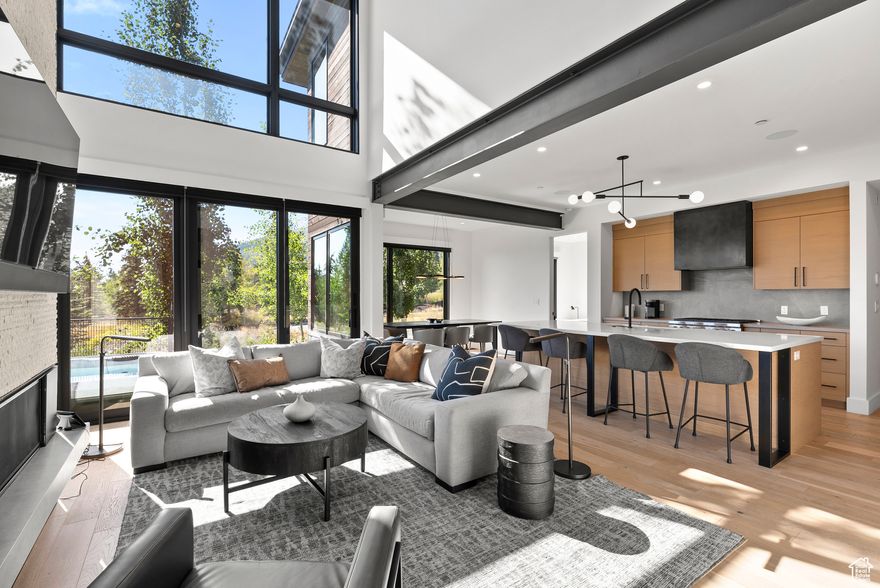 Nestled in the heart of picturesque White Pine Canyon in Canyons Village, this mountain residence embodies a perfect mountain escape. Located just steps from the new Sunrise 10-Person Gondola and set on a peaceful, no-through street, this exclusive Ridge at Canyons enclave is designed for pure enjoyment, relaxation, and elevated living. With five bedrooms, the residence provides generous accommodations, ensuring that family and guests may enjoy the space with utmost comfort and privacy. Soaring ceilings, white oak flooring, and steel beam accents highlight the home's architectural sophistication, while expansive windows frame breathtaking views of the Aspens and White Pine Canyon peaks. At the heart of the home, a dramatic two-story limestone fireplace anchors the main living area, complemented by curated designer furnishings.  Offered fully turnkey, the home includes smart technology such as Lutron lighting, electronic shades, security system, and integrated sound. The chef's kitchen boasts Wolf appliances and a 10-foot island for prep or casual dining, flowing into a formal dining area surrounded by panoramic mountain views perfect for morning coffee, aprs-ski, or holiday meals. Dual primary suites include a main-level retreat with expansive windows, dual closets, and a spa-style bath with dual vanities. The upper-level suite features a fireplace, private balcony, soaking tub, walk-in shower, dual vanities, and heated floors for a true spa experience. Two additional bedrooms, one en suite offer generous guest space. A glass-enclosed walkway leads to a versatile flex area ideal for work or creative pursuits. Laundry rooms are conveniently located on two levels. The lower level impresses with 10-foot ceilings, entertainment space, beverage station, pool and poker tables, plus a custom bunk room with en suite bath. A heated two-car garage includes custom cabinetry and an EV charging outlet.