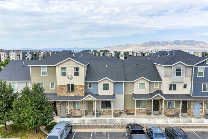 Modern townhome community featuring varied siding textures, stone facade elements, dark shingle roofing, and individual…