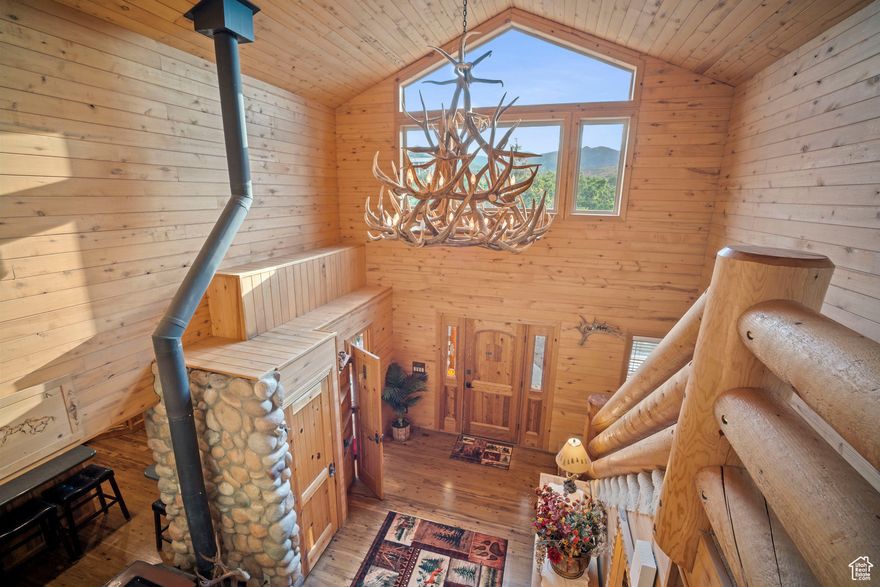 Experience a perfect blend of rustic charm and modern luxury in this stunning log home. Massive windows frame breathtaking views, showcasing nature's beauty through every season. Step onto the expansive front and back decks, perfect for entertaining guests or unwinding on the porch while soaking in the serene surroundings. Enjoy wildlife and mountain views as your daily entertainment. Located on 3.18 acres in High County Estates, just 1.6 miles up a year-round dirt/gravel road to paradise. Culinary water is provided by the City of Herriman and septic tank for sewer. The vaulted great room is a true centerpiece of this home - a soaring space of light and air, where you can relax by the fire. The main floor primary suite and 2 spacious upper-level guest bedrooms, plus 3 baths (and a half bath in the garage), provide plenty of room for family and guests. Thoughtfully crafted with wood flooring, knotty alder cabinetry, and warm countertops, newer appliances, PLUS a loft family room, add to the expansive feel. The unfinished walk-out basement allows for expansion as your needs require. The garage has space for up to six cars or a mix of toys and autos. Add the corral to the east of the property and enjoy Rural living just minutes from civilization.
