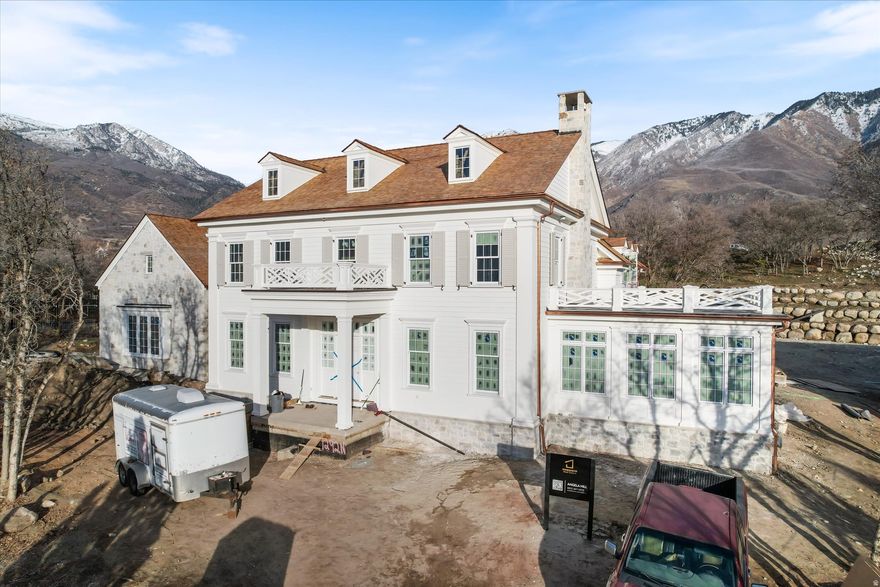 Introducing a classically designed Colonial Revival from the esteemed UV Parade of Homes Award Winning Builder, Grove Homes. You do not want to miss this beauty tucked into a generously sized lot with a private backyard and breathtaking views of the Wasatch Range. Every detail of this incredible home has been meticulously planned by award-winning designers Alex Adamson for the interior and Emily Brooks Wayment for landscaping. The interior will impress with custom millwork and cabinetry, expertly curated fixtures, and intentionally designed living spaces. The open entryway gives way to a formal dining room, formal sitting room and an entertainer's great room with wall-to-wall French doors. This home also features a massive sunroom that can function as a private study or music room. The kitchen is a home chef's haven with a Wolf range, Subzero refrigeration, dual Cove dishwashers, and walk-through scullery with pebble ice maker. A window adorned breakfast nook will feature built-in bench seating. The owner's wing of the main level includes a fireplace and sitting area, dual closets, steam shower and dual water closets. The second level will lead to an open loft area, three spacious en-suites with walk-in closets, and a secondary laundry room. The basement is the ultimate fun zone: recreation area with bar,  open style theatre room, dedicated golf simulator room, glass door gym, and an 1100 sq ft sport court! Two additional large bedrooms with en-suite bathrooms finish out the space. The space above the garage is left for the new owner to customize in the future as an apartment, office, play area or extra storage. Full landscaping included in price. Do not miss out on the opportunity to call this timeless architectural beauty *home*. Expected completion Summer 2026.