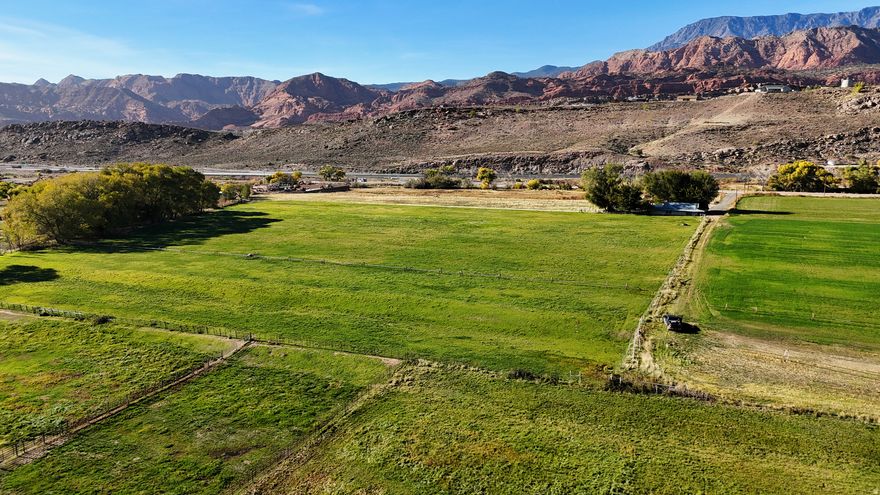 This 10-acre property is located within Leeds city limits in Washington County, Utah. The parcel has a long history of agricultural use and features mostly flat ground with productive soil characteristics. The parcel is just minutes from Interstate-15 with convenient access to both north and south onramps. The layout and zoning provide flexibility, allowing the property to remain intact as a single rural holding or be divided into several 1-plus-acre lots, subject to city approvals and required improvements.  Access to the property is near Main Street in Leeds, offering proximity to town amenities while maintaining a sense of separation through mature trees and surrounding land uses. A neighboring riding arena and established agricultural properties contribute to a semi-rural setting. While close to town, the parcel maintains privacy and open space characteristics that are increasingly limited within city boundaries.  City water is available to the property, which supports both residential considerations, while senior priority private water shares support the agricultural production. Electrical power is located nearby and could be extended to future building sites. Sewer service is not available, and development would require individual septic systems. Some road improvements would also be necessary before subdivision or construction, and buyers should verify all requirements with the City of Leeds.  The terrain is primarily level, which may reduce grading needs depending on the intended use. Views from the property include surrounding red rock formations and open skies typical of southwest Utah. The soil quality reflects its agricultural past and may support continued farming, hobby agriculture, or landscaped residential uses where permitted.  Leeds is a historic southern Utah town known for its agricultural roots and long growing season. Main Street still features buildings dating back to the late 1800s, reflecting the area's early settlement history. The community offers a quieter pace while remaining closely connected to larger population centers.  St. George is located approximately 15 minutes south of the property on I15 and provides access to regional shopping, medical facilities, dining, and employment opportunities. Washington County continues to experience steady growth, supported by transportation infrastructure, recreation, and tourism.  The greater Zion area is widely recognized for its public land access and outdoor recreation. The property is located near Quail Creek State Park, Sand Hollow State Park, Gunlock State Park, Snow Canyon State Park, the Red Cliffs Desert Reserve, and Zion National Park. These areas offer opportunities for boating, hiking, mountain biking, off-highway vehicle use, and scenic exploration. With several hiking and biking trails accessible less than 2 miles from the property.   Washington County also hosts a range of regional events, including endurance races, off-road events, and seasonal competitions. Golf courses are located throughout the county, including courses associated with professional tournament play. These amenities contribute to year-round recreational use without being located directly on the property.  Wheel line sprinklers, additional water rights, or adjacent property may be negotiable, subject to a separate agreement. Buyers are encouraged to verify zoning, subdivision standards, utility connections, and allowable uses directly with the City of Leeds, the Leeds Domestic Water Users Association, and Washington County. This offering presents an opportunity to acquire a sizeable parcel within city limits with multiple potential future paths, depending on buyer objectives and approvals.