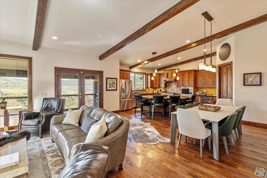 Lake. Mountains. Luxury. Your Alpine Escape Awaits.  Perched above the sparkling waters of Jordanelle Reservoir, with sweeping lake and mountain vistas, this 3,545 sq ft retreat blends refined luxury with year-round adventure. Just five minutes from world-class skiing at Deer Valley, this 4-bedroom, 4-bath residence offers the rare combination of effortless ownership, resort proximity, and investment potential. Designed with both relaxation and entertainment in mind, the home's open-concept great room boasts vaulted ceilings, solid walnut floors, and a striking stone fireplace that invites cozy gatherings after a day on the slopes. The chef's kitchen is appointed with granite countertops, a Thermador gas range, large center island, and walk-in pantry-ideal for hosting aprs-ski dinners or summer sunset soires. Three expansive outdoor living spaces-two large balconies and a walkout garden-level patio-frame uninterrupted views of the lake and surrounding peaks. Whether sipping morning coffee above the misty water or unwinding with evening wine under a painted alpine sky, every moment here feels elevated. The floor plan offers generous suites for family and guests, including a luxurious primary with spa-style bath. A private theater room provides the perfect place for movie nights, while premium upgrades throughout-two fireplaces, designer carpet, and high-end finishes-enhance comfort and style. Ownership is truly turnkey thanks to an HOA that maintains the roof, siding, and exterior grounds-perfect for "lock-and-leave" convenience. A rare two-car garage provides ample storage for vehicles, gear, and toys. Step outside and immerse yourself in the endless recreation this area offers: ski, hike, or bike world-class trails; fish blue-ribbon waters; or spend summer days boating on Jordanelle Reservoir. From here, Park City's historic Main Street is just 15 minutes away, and Salt Lake City International Airport is under 40 minutes, ensuring easy access for weekend getaways or seasonal living.