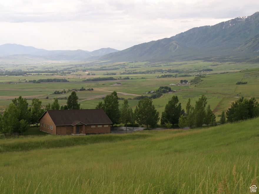 You drive up to the electric gate, opening the gate with the remote. You drive down the 14' wide asphalt driveway to the all brick house and four-bay garage with electric doors, controlled by remotes. The garage has exterior and interior lighting, with motion sensors making it easy to see at night. The house has security screens on all exterior doors.  Even a sledge hammer won't allow entry. The great room has a high peaked ceiling. 9' is the lowest ceiling in the house. A huge, open space, combines the living area and the kitchen, with cupboards that have pull-out drawers and commanding views across the valley, through large windows. All fixtures are well taken care of, like new. The patio has mature shade trees and views of more than 180 degrees across the valley and the Little Bear river to the surrounding mountains. The valley is a flyway for the birds. Just part of all the wonderful nature you get to observe from the comfort of your own home. If you have horses, there is a round pen and a barn with water and electricity. A locking tack room will keep all your saddles and gear secure. There is  paddock area behind the barn with a large, walk through door for the horses to get to the feeders, inside the barn.  The barn has a large open area, with a high ceiling  for storing hay. Ceiling lights make it easy to work, day or night. The shed behind the barn is fenced for raising chickens.   The house sits in the middle of 79.41 acres, insuring privacy, with the best insulation...space.  Property accessed on a multi family private gravel road. Buyer and buyer agent to verify all info. Selling agent to be present at all showings.  No showings until April 10th
