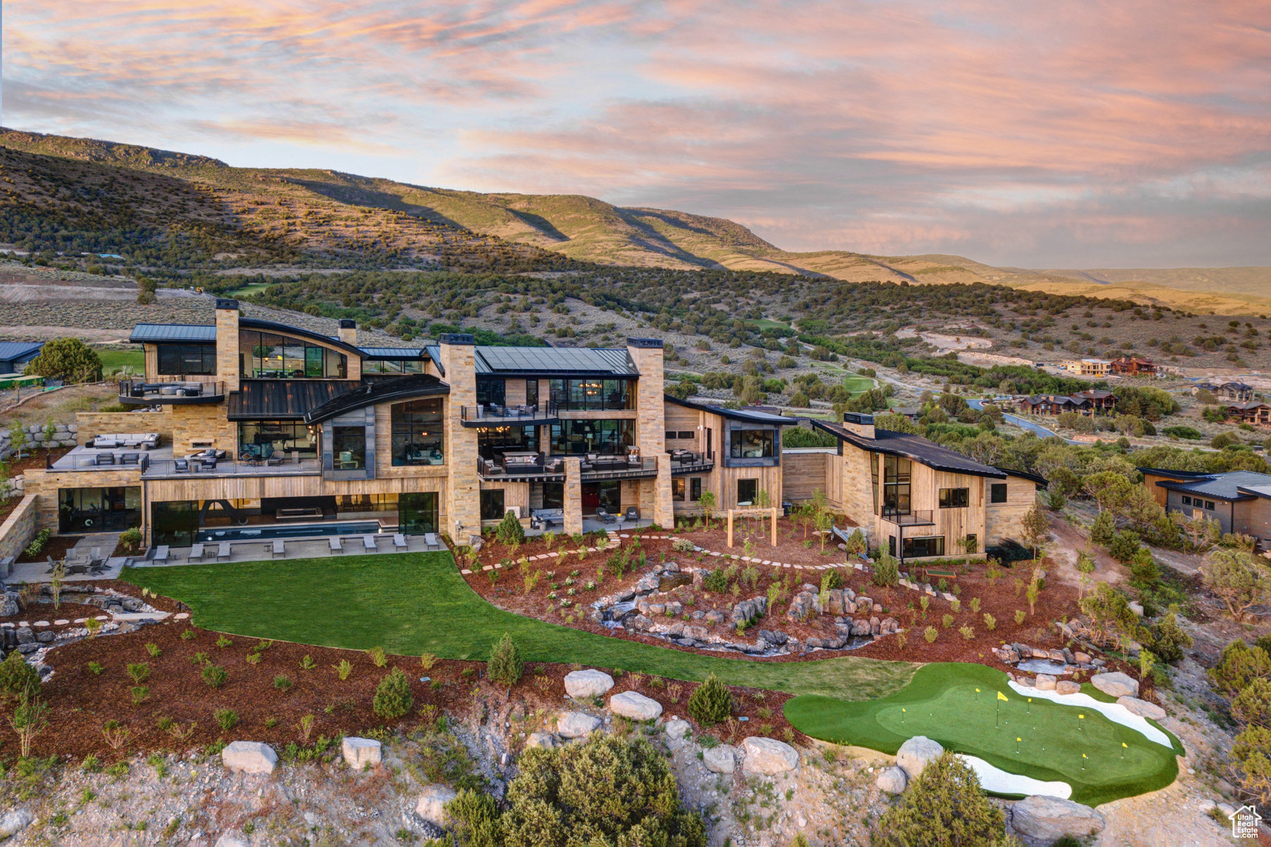 Perched on top of the most prominent ridge in the gated Red Ledges community and featuring one of the most magnificent views in all of the Mountain West, this estate has been designed by award-winning architect, Michael Upwall, to stand out as one of Utah's most distinguished mountain modern homes. Located just 15 minutes from Deer Valley Ski Resort, the owner spared no expense to guarantee 360 degree panoramic mountain views with the conveniences of living in a gated community & club. The home offers resort style amenities that are second to none and are perfect for a multi-generational family retreat or the ultimate corporate entertainment venue. Shawn Johnstun Construction showcased his work using the finest materials and craftsmanship, with an innovative and cohesive layout for a seamless flow throughout almost 21,000 square feet of living space. This exceptional residence was designed around a comprehensive suite of amenities, featuring an indoor sports court for basketball & pickle ball, a 50 foot indoor/outdoor pool, hot tub, a personal fitness gym with adjoining steam room & sauna suites. Entertain friends and family in your golf simulator, billiards & recreation room or on your 2000 sq ft rooftop putting green. Enjoy peaceful sunsets relaxing and listening to music on one of the many outdoor living terraces. The home is offered fully furnished, with artwork, fixtures and furnishings by renowned designer Paula Berg. 7 bedrooms and 11 bathrooms are highlighted by a generous master bedroom suite, all en suite bedrooms and a private two-bedroom casita residence with its own garage, kitchen & great room for longer guest stays. A custom bunk room features 9 bunk beds with plenty of space for the grandkids and little ones. The spectacular landscape design is accented by massive boulders sourced in Wyoming, a series of cascading water features, a large lawn area, play area for the kids and even your own 75 yard par 3 golf hole with an infinity edge green.  Several fire pit areas and outdoor fireplaces offer a cozy spot to take in the clear summer nights and full spectrum of the stars. The 2000 acre Red Ledges gated community offers world-class Jack Nicklaus signature golf, multiple clubhouses and restaurants, tennis & pickleball courts, pools & fitness centers, ski clubs, an equestrian center and hiking and biking trails for its members. This is your chance to own one of the premier properties in all of Utah.