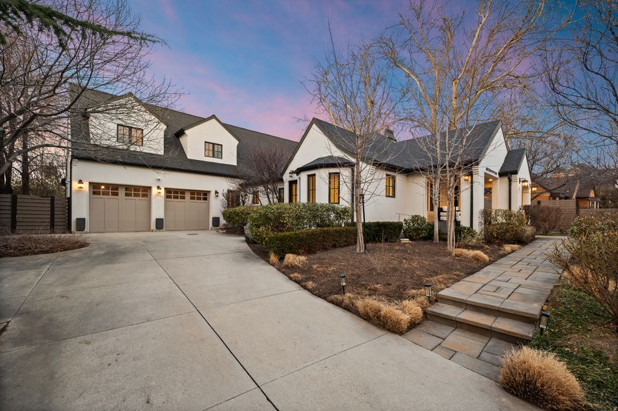 A rare Millcreek offering, this historic 1937 residence was fully reimagined through a no-expense-spared renovation, blending timeless character with elevated modern design. A gallery-style hall anchors the layout, connecting the main living spaces and opening to a private yard and terrace-ideal for both everyday living and entertaining.  Light wood floors, crisp white walls, and custom millwork showcase the home's architectural detail, while dark-trimmed windows add depth and contrast throughout. The expansive great room features custom built-ins, a statement marble fireplace, and a showpiece kitchen with premium cabinetry, designer lighting, and top-tier appliances.  The main-level primary suite is a private retreat, complemented by an adjoining speakeasy-inspired study with a dramatic lighted granite feature wall, creating an intimate and unexpected space for relaxing or entertaining. Additional bedrooms with vaulted ceilings, a flexible media room, a lower-level theater, and generous storage round out the home. Refined outdoor spaces include an inviting front porch, manicured gardens, custom fencing, and a secluded terrace that extends the living experience.  A truly distinctive home offering exceptional design, privacy, and location in one of Millcreek's most desirable neighborhoods.