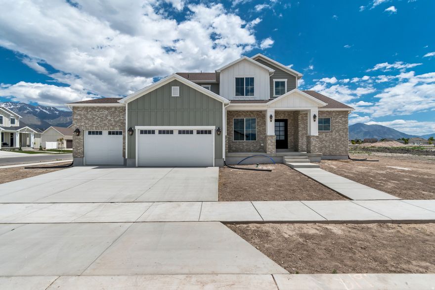 Nestled in a quiet Vineyard neighborhood just minutes from beautiful Utah Lake. Designed for both everyday comfort and unforgettable entertaining, this home showcases exceptional custom finishes and an inviting open gathering space filled with natural light from oversized soaring windows.  Make a statement from the moment you arrive with the oversized front door featuring innovative smart glass technology, allowing you to instantly shift between clear and frosted glass at the touch of a button for on-demand privacy and modern elegance.   The thoughtfully designed kitchen is the heart of the home, featuring a large pantry, custom lighting, beautiful backsplash, oversized quartz island, custom cabinetry throughout, and a stunning custom vent hood. A breathtaking wood staircase serves as a striking architectural centerpiece, adding warmth, character, and timeless design to the home.  Retreat to the private main-level primary suite, where abundant windows create a bright and peaceful escape complemented by a spacious, luxurious ensuite bath. Upstairs, a large landing leads to three additional inviting bedrooms, all with walk-in closets, including one with its own private ensuite, creating the perfect space for guests or multigenerational living.  The expansive unfinished basement offers incredible potential, including a convenient rear walk-up entrance and plenty of room to grow, customize, and make your own.  Square footage figures are provided as a courtesy estimate only and were obtained from county records. Buyer is advised to obtain an independent measurement.