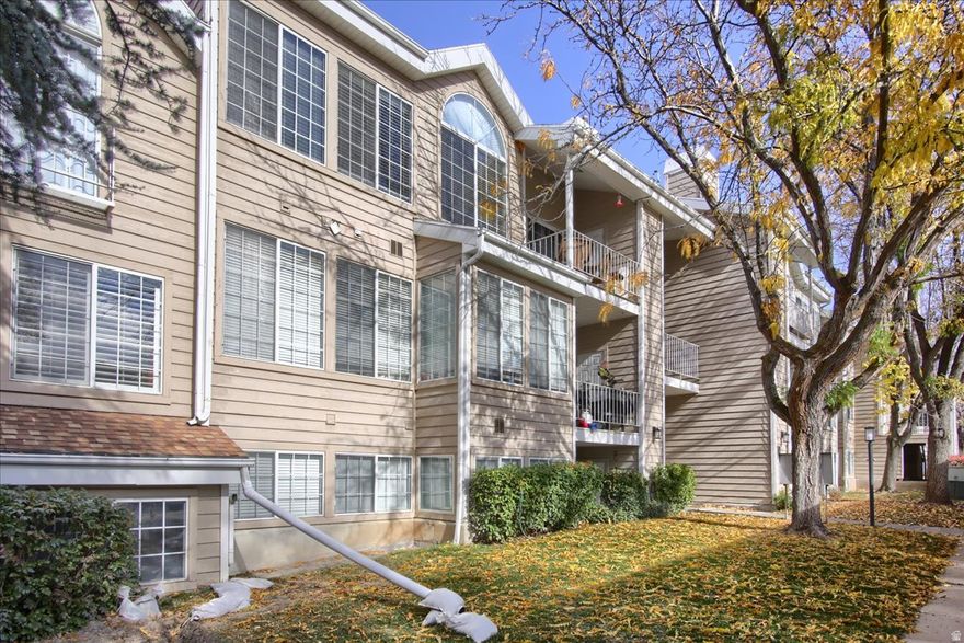 Welcome home to this bright and spacious top-floor condo in the desirable Carriage Crossing community. You'll love the open, airy feel of the two-story layout with tall, vaulted ceilings, large windows, and a cozy gas fireplace. The large upstairs loft adds incredible versatility - perfect for a home office, TV room, or even a third bedroom. Enjoy updated flooring and modern fixtures and hardware throughout. The kitchen has been tastefully refreshed, and the primary suite features an attached bathroom for added convenience. Step outside to a covered balcony with a storage closet for added functionality. This park-like community offers beautiful grounds and amenities including a clubhouse, pool, and tennis court. HOA dues cover water and sewer, and residents enjoy private gate access to Smith's Marketplace. The public library and police station are just across the street, with easy access to I-15, bus lines, and historic Main Street. Only 15 minutes to Salt Lake International Airport and downtown Salt Lake City. Immaculately cared for and move-in ready, this home can be sold furnished for the right offer. Experience low maintenance living in a peaceful, well-maintained setting!