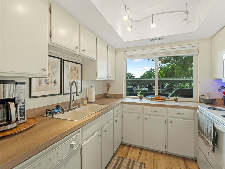 Welcome to your peaceful retreat in the heart of the highly desirable Three Fountains East community. This beautifully maintained 2-bedroom, 2-bath condo offers a perfect blend of comfort, convenience, and charm. The spacious layout features updated laminate flooring, large windows for abundant natural light, and dual-function blinds for versatile privacy and style. The generously sized primary suite includes a walk-in closet and a private ensuite with an updated shower-perfect for relaxing at the end of the day. Modern touches like recessed lighting and energy-efficient windows enhance the home's comfort and functionality. Additional perks include a new water heater (2023), included appliances (washer, dryer, and refrigerator), and 2 dedicated covered parking spots. Step outside to enjoy the community's mature landscaping, winding paths, and serene green space-plus access to a clubhouse, pool, tennis courts, and RV parking. Centrally located near Wheeler Farm, golf courses, dining, shopping, and major freeways (I-15 and I-215), this condo is truly a hidden gem. Whether you're seeking low-maintenance living or a well-connected location, this home checks all the boxes.