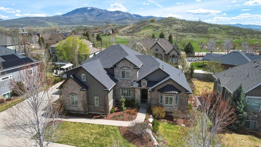 This beautiful, custom-built home in Mountain Green sits just 10 minutes South of Snowbasin Ski Resort where the Downhill, Super-G, and other Olympic events will be held. It offers breathtaking mountain views and is nestled on a quiet street. With over 5,500 finished sq feet you'll immediately notice the great room with vaulted ceilings, spacious and open floor plan with ample natural light.The primary bedroom and office are on the main floor with three more large bedrooms on the 2nd floor and two bedrooms in the basement.. The primary suite is a true sanctuary. Offering a spacious bedroom, a fully remodeled, luxurious ensuite bathroom with a soaking tub and separate shower. The large walk-in closet contains its own washer and dryer. Home chefs will appreciate the updated kitchen featuring a large 48" Thermador Range with steam and convection ovens, Thermador dishwasher, pot filler, and a large hidden pantry. The large basement includes a kitchenette, theater room, gym, two bedrooms, bathroom, and plenty of storage space.. The theater room is set up with a projector, surround sound system, and all of the theater furniture is included with the home.  The large lot boasts almost a third of an acre and is perfectly situated to enjoy the mountain views from the covered back deck. The backyard is fully fenced and offers beautifully maintained flower beds and raised garden beds. Professional landscape lighting is featured in both the front and backyard. In addition to the oversized three car garage, there is plenty of room in the loft for extra storage. RV parking on the side of the house. This home was meticulously designed to feel spacious and clean.  Since then, it has been carefully maintained and is move-in ready for the new homeowners.   Square footage figures are provided as a courtesy estimate only and were obtained from appraisal.  Buyer is advised to obtain an independent measurement.