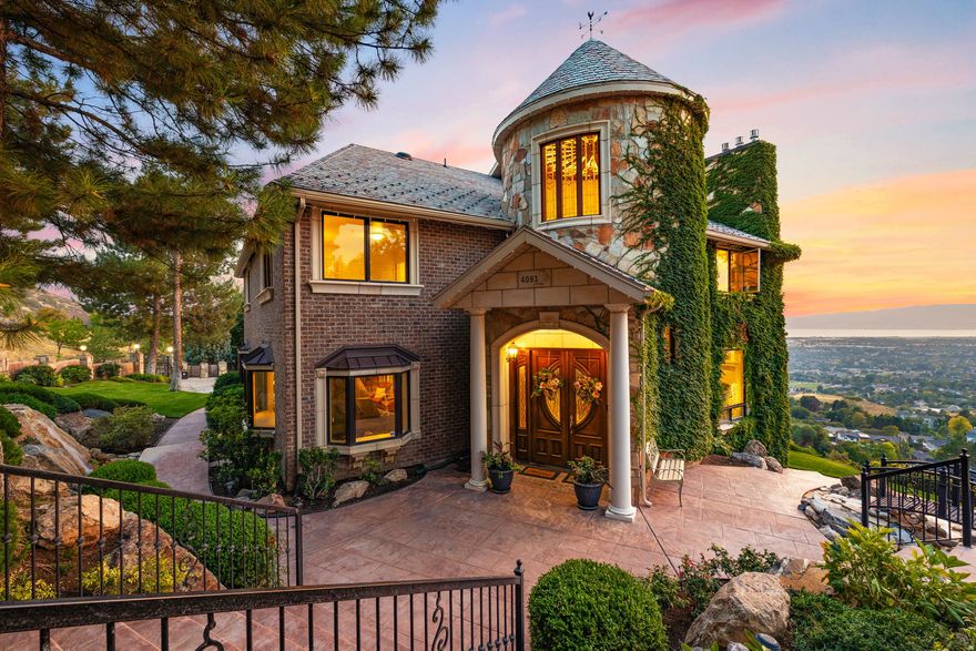In a world of gray-and-beige interiors, laminate flooring, and builder-grade finishes, 4093 N Imperial Way stands apart. Set on 1.7 acres with sweeping views of Utah Lake, the valley, and the surrounding mountains, this French chateauinspired estate offers a level of character, craftsmanship, and presence that is nearly impossible to replicate today.  Originally built as an entertaining showcase, the home was later extensively rebuilt and improved with a long list of structural and cosmetic upgrades, including a 50-year DaVinci Slate roof, updated windows and doors, a redone stone-and-brick exterior, extensive decking, upgraded mechanical systems, refreshed landscaping, and more. The exterior features real quartz stone, artisan brick, cast concrete trim, gated access, mature landscaping, water features, and a private resort-style backyard complete with an 18' x 40' pool, hot tub, diving board, slide, pool house, basketball court, playground, and open lawn space.  Inside, the home feels grand, warm, and unapologetically custom. The entry turret features a dramatic circular staircase and stained-glass ceiling, while heated marble floors, black granite accents, custom wrought iron, coffered ceilings, intricate millwork, stained glass details, chandeliers, and multiple fireplaces carry the home's old-world elegance throughout. The kitchen was built for hosting, with cherry cabinetry, granite countertops, dual dishwashers, double ovens, a large island, and a fireplace-connected living space that opens toward panoramic views.  The layout offers both formal and casual gathering spaces, including a banquet-sized dining room, music room or office, large view-facing living areas, a 30' x 22' theater room, whole-home audio, a basement kitchenette, multiple laundry areas, and generous bedroom suites. Expansive decks, walkout spaces, and multiple separate living areas make the home exceptionally well-suited for entertaining, multi-generational living, or simply enjoying one of Provo's most unique private settings.  The lot itself is a major part of the offering. With approximately 350 feet of street frontage, rare usable acreage, and a north portion that was historically separate and still has its own utility service, the property may offer future subdivision or build potential. Buyer to verify all development possibilities with Provo City.  Located near Provo Canyon, Little Rock Canyon, hiking trails, Riverwoods shopping and dining, Sundance Resort access, and major transportation corridors, this is one of Provo's most distinctive luxury estates: bold, timeless, and completely unlike anything else on the market.  Square footage figures are provided as a courtesy estimate only. Buyer is advised to obtain an independent measurement and verify all property details.