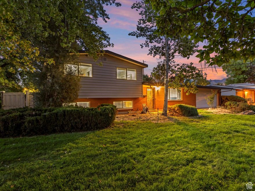Experience the perfect blend of comfort, style, and unbeatable location in this beautifully updated home, ideally situated on a quiet, tree-lined street in one of Murray's most desirable neighborhoods. Step inside to find a thoughtfully designed floor plan featuring 3 spacious bedrooms and 2.5 bathrooms. The inviting main level boasts a generous living room with a cozy fireplace making an ideal gathering space for friends and family. A bright and airy sunroom with large windows and sliding doors opens to the private backyard, offering a perfect year-round retreat. Whether used as a home office, gym, playroom, or flex space, this versatile room adds lifestyle flexibility to your daily routine. The open-concept kitchen is both stylish and functional, complete with custom gray cabinetry, stainless steel appliances, gas range, built-in microwave, and an included refrigerator. Enjoy meals at the kitchen counter or in the adjacent dining area that seamlessly connects to the heart of the home. Upstairs, you'll find three comfortable bedrooms, including an updated full bathroom with dual access to both the primary bedroom and hallway. The lower level offers a generous rec room, an additional updated  bath, and potential for a 4th bedroom-perfect for guests or expanding needs. Recent upgrades include newer wood-tone flooring, modern lighting, fresh paint, and newer windows. Step outside to a fully fenced backyard oasis featuring a lush lawn, spacious patio, and beautiful landscaping framed by mature trees and vibrant plants. An expansive two-car garage, large driveway, and space to add RV parking provide ample storage and flexibility. Location is everything and this home delivers. Just minutes from Intermountain Medical Center, high-end shopping at Fashion Place Mall, top-rated schools, trendy restaurants, and quick freeway access, you'll enjoy a short commute to anywhere in the Salt Lake Valley. Plus, you're only a quick drive from world-class ski resorts, hiking trails, and outdoor adventures. Live where lifestyle meets convenience-this is the home you've been waiting for. Buyer to verify all. The square footage is from an appraisal measurement. Decor items not included, virtual staging was used in the images.