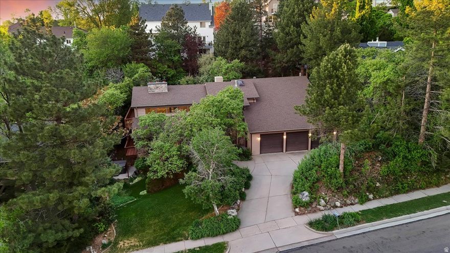 Set on the east bench in Farmington, this spacious two-story home offers privacy, character, and a setting that's hard to find. The mature lot is filled with established trees and colorful landscaping, creating a peaceful backdrop with plenty of room to relax or entertain.  Inside, you'll find generous living spaces, large rooms, and a layout designed for both everyday living and gathering. A massive recreation room in the basement provides the perfect spot for game nights, holidays, or keeping everyone entertained year-round. Wood-burning fireplaces on each level add warmth and personality throughout the home.  The oversized 3-car garage includes a suspended slab with additional space below-ideal for storage, a workshop, or future possibilities. A hot water boiler system offers efficient, consistent heating.  This home has been lovingly cared for by its original owner and is ready to provide memories for the next owner for years to come.  Step outside to a side patio with a conveniently located hot tub-easy to enjoy year-round.  Located just minutes from Station Park for shopping and dining, and close to Lagoon Amusement Park, this home combines space, comfort, and convenience in one of Farmington's most desirable areas.