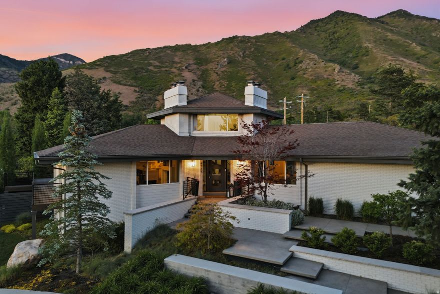 If you have ever stayed at a Ritz-Carlton or Montage hotel, you know the feeling. You leave thinking, I wish I could live like this every day. At 4115 Gary Road, located in Salt Lake City's premier Olympus Cove neighborhood, that feeling becomes home. Set on 0.74 flat acres with striking views of Mount Olympus, this property delivers true hotel-grade indoor-outdoor living. Multiple outdoor fire pits, a swim spa, expansive entertaining spaces, and a yard large enough to host your own family Olympics create a lifestyle that feels both elevated and effortless. For the car lover, there are four garage spaces. For the fitness-minded, a detached true gym means you never have to leave home. The pull-up driveway, bold architecture, and resort-style setting make an immediate impression, but the home continues to unfold once inside. The interior features vaulted ceilings, multiple fireplaces, ensuite bedrooms throughout, a butler's kitchen, a bar, a theater, and an office that could easily live as a library, lounge, or hangout room, surrounded by nearly 360-degree views. With 6 bedrooms, 5.5 bathrooms, seamless indoor-outdoor living, and a location just minutes from the best of Salt Lake City, this is a rare opportunity in one of the city's most sought-after neighborhoods. Welcome home. Welcome to Olympus Cove. Welcome to Salt Lake City. Located approximately 20 minutes from downtown Salt Lake City and Salt Lake City International Airport, and about 35 minutes from Park City.