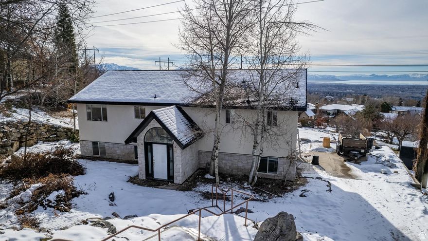 This property is an absolutely unique piece of land with mesmerizing mountain and lake views that will never bore you! The extra large deck will allow space to relax to watch sunsets while sipping your favorite beverage. The open kitchen and living space allows for intimate gatherings so that the chef doesn't miss a beat! The Master is on the main, upstairs floor and has vaulted ceilings with walk-in His/Her Closets. This master also has its own Master laundry! On a rare almost 3/4 acres, this home has so many opportunities. Whether you're a couple looking to rent to your family or use as an owner occupied Airbnb, this finished basement will generate cash flow that will create a comfortable mortgage payment and opportunity for families to bond and create memories. This home has an assumable VA loan at 3.125% ($458K balance & $2,484 payment)! There's also lease with option to purchase options with large down payments. This home has a hot tub that has been well-maintained, a small forest area that attracts live deer to nonchalantly wander and a cement court that can be used for tennis, pickleball or can be easily made into a basketball court. With clear, crisp views of beautiful sunsets every night, and complete, beautiful renovations with brand new appliances, all new siding and a brand new roof, flooring, paint and water heater, you will find comfort and longevity in this home night after night! Square footage figures are provided as a courtesy estimate only and were obtained from tax records. Buyer is advised to obtain an independent measurement. Listing agent has an interest in the property.