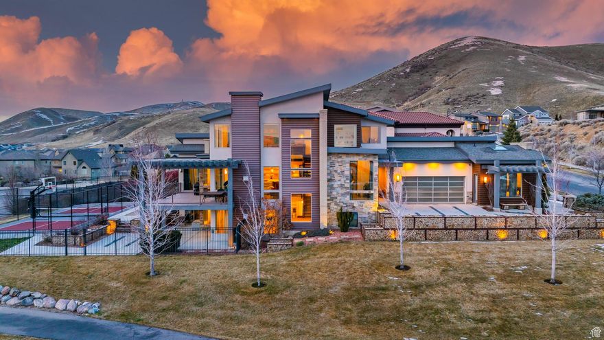 Experience the perfect blend of modern architecture and organic elegance in this one-of-a-kind custom home in the coveted Traverse Mountain community. Showcasing over 6,100 sq ft of meticulously designed living space, this 7-bedroom, 7-bath home offers striking design elements, soaring ceilings, and expansive mountain views. The gourmet kitchen is a true showpiece, featuring sleek quartz countertops, a built-in Sub-zero fridge, and warm wood cabinetry that complements the contemporary brickwork and exposed steel beams. The open-concept layout flows into a dramatic great room with floor-to-ceiling windows, a statement fireplace wall, and designer lighting that adds warmth and artistry. The luxurious main-level primary suite is a private retreat with panoramic views, a spa-like bathroom with soaking tub, and a walk-in shower with rainfall features. Upstairs and downstairs offer thoughtfully laid-out bedrooms, Jack-and-Jill bathrooms, and flexible living spaces ideal for a media room, home office, or gym. The fully finished walkout basement is an entertainer's dream with a second kitchen, dining area, and spacious lounge. Step outside to enjoy the covered patio, custom deck, and fenced sport court-perfect for basketball or pickleball with friends and family. Additional highlights include polished concrete floors, floating stairs with mesh paneling, multiple modern fireplaces, and smart home features throughout. All set on a 0.28-acre lot within an HOA that offers access to a gym, pool, playground, and more. This home is more than just a statement-it's a lifestyle.