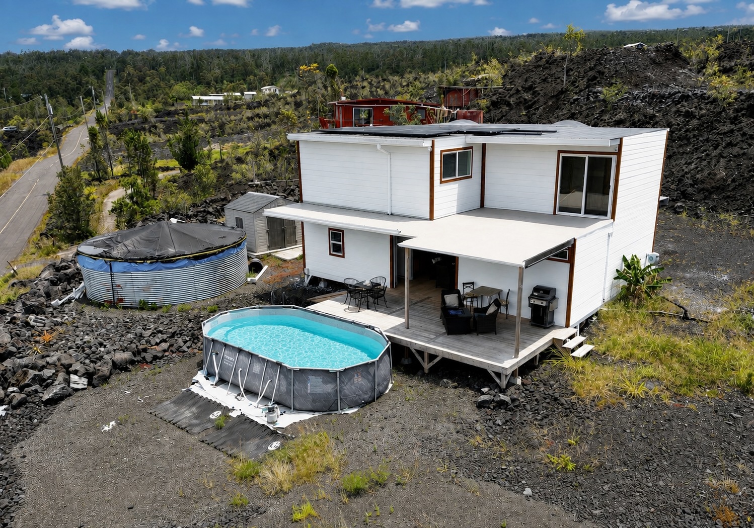 Front elevation w/panoramic ocean views, a covered lanai, above-ground pool & new catchment tank.