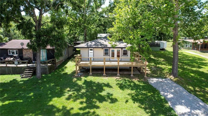 Ideally positioned on a double lot in a peaceful, friendly neighborhood, with stunning lake views from the spacious deck of this beautifully updated second-tier home, This inviting property has been extensively improved with major updates including new windows, exterior doors, a new well pump, and a new septic system—offering both comfort and confidence for the next owner. Inside, you’ll love the fresh, modern feel with updated flooring, stylish finishes, and an open layout designed for easy living and entertaining. Natural light fills the space, creating a warm and welcoming atmosphere throughout. Enjoy the convenience of being just a short walk to the community lakefront area, with quick access to a boat ramp at Bottoms Up Marina nearby—perfect for days on the water. Don't miss this affordable opportunity to own your slice of life at Lake of the Ozarks.