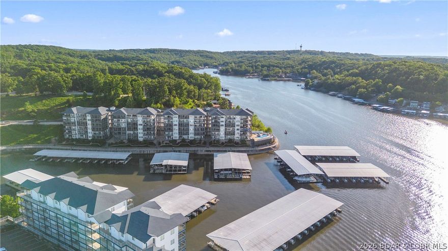 This exceptional 3-bedroom, 2.5-bath fully furnished lakefront condo offers the ultimate "turn-key" Lake of the Ozarks experience. Positioned as the original "model" unit, it boasts superior details and numerous upgrades, including crown molding with accent lighting, stainless steel appliances, and granite countertops. Some of the key condo features are elevator access that opens directly in front of  the unit. Open-concept living, dining, and kitchen area with tasteful, included furnishings. Screened-in lakeside patio equipped with high-quality matching Polywood furniture. A cozy fireplace designed with plumbing capabilities to allow an outdoor spigot for grilling. Access to three community pools. Includes a 12' x 36' boat slip. Conveniently located at the 2mm, providing quick access to restaurants, golf, and shopping. Complete your lake lifestyle with the optional, separate purchase of the seller's boat and hoist: 2015 Bennington Tritoon 25R, 250HP Mercury Outboard with only 415 hours, 10,000 lb capacity hoist already installed in the slip. This is a rare opportunity to purchase a meticulously maintained, model-level unit with top-tier amenities at the Midwest Coast.